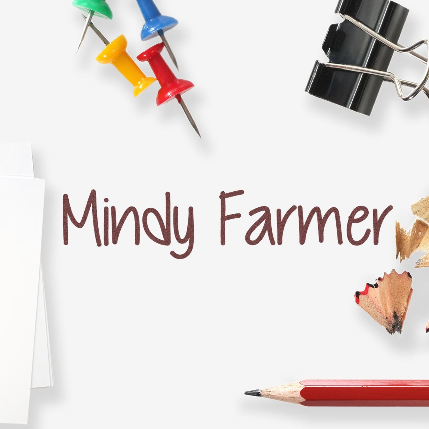 Mindy Farmer printed on white paper with colorful push pins, black binder clip, and red pencil for stamp and seal branding.