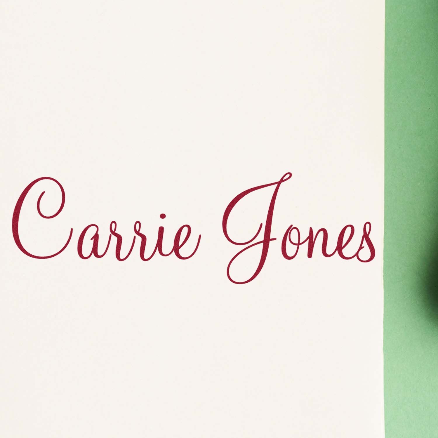 Maroon Carrie Jones custom stamp and seal on white paper with a green edge.