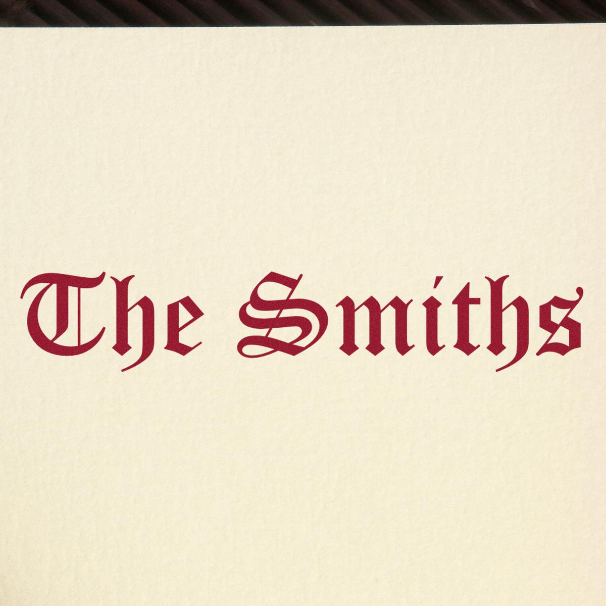 Red blackletter The Smiths stamp and seal on cream paper background.