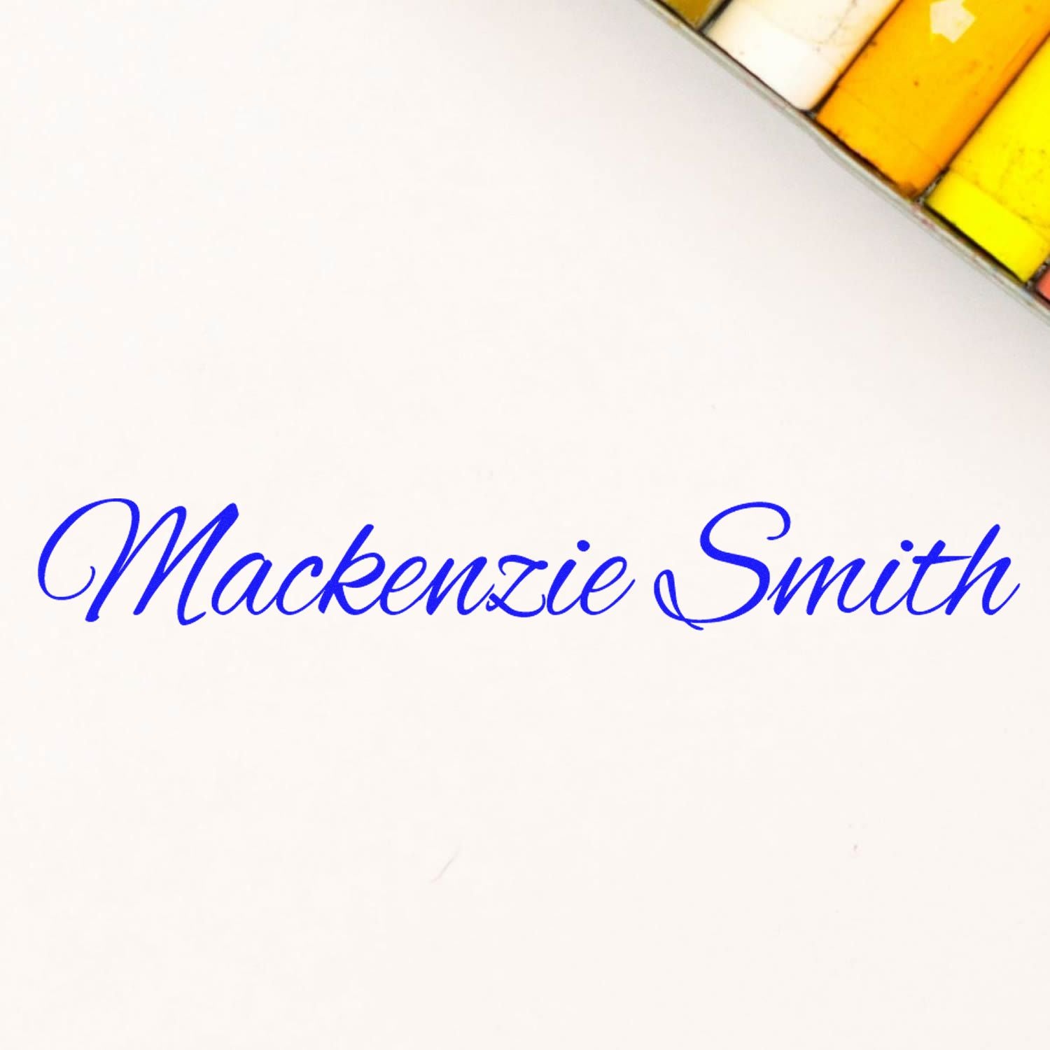 Blue cursive Mackenzie Smith stamp on white background, with yellow and orange seal swatches in the corner.
