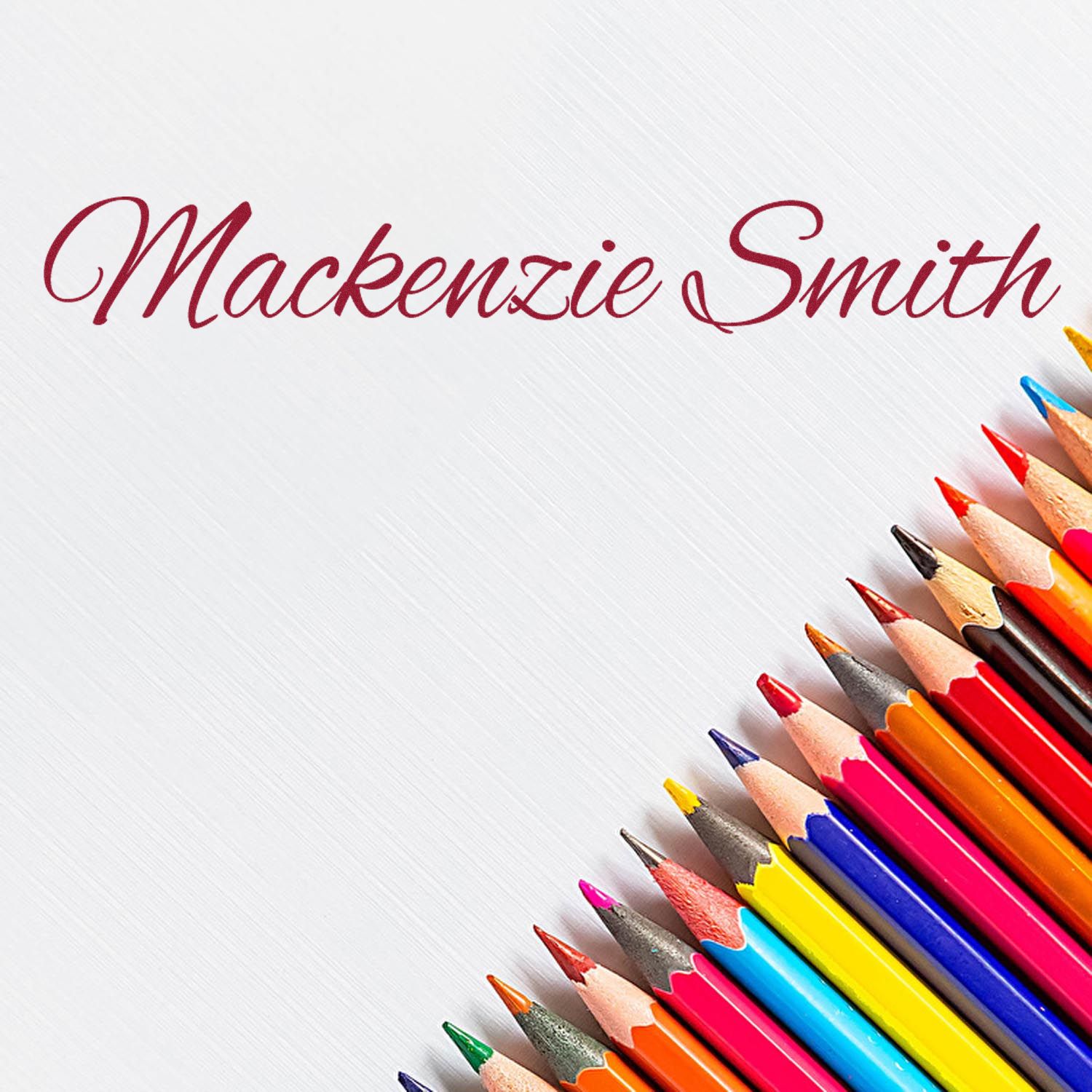 Custom stamp and seal with burgundy Mackenzie Smith script on white, accented by colorful pencils.
