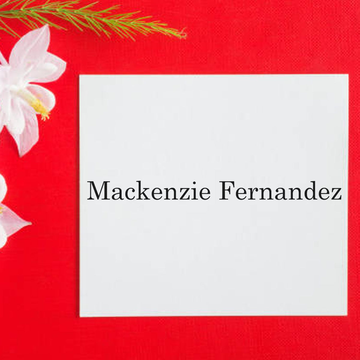 White personalized stamp seal with Mackenzie Fernandez on a bright red background, accented by white flowers.