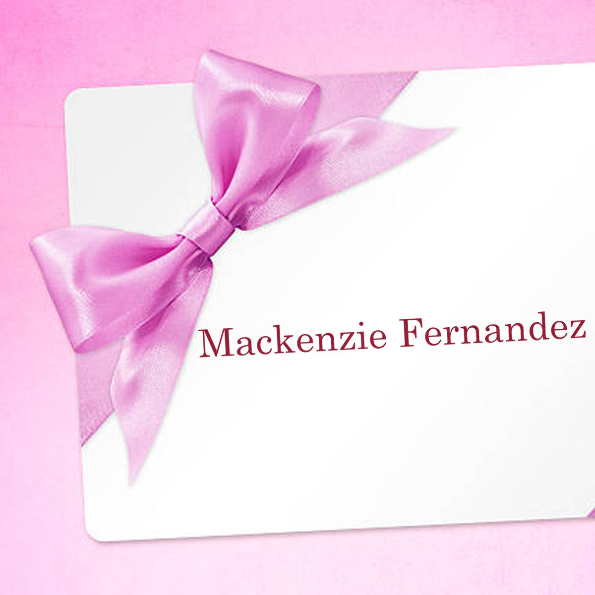 Pink custom stamp and seal card with satin bow and Mackenzie Fernandez in red text.