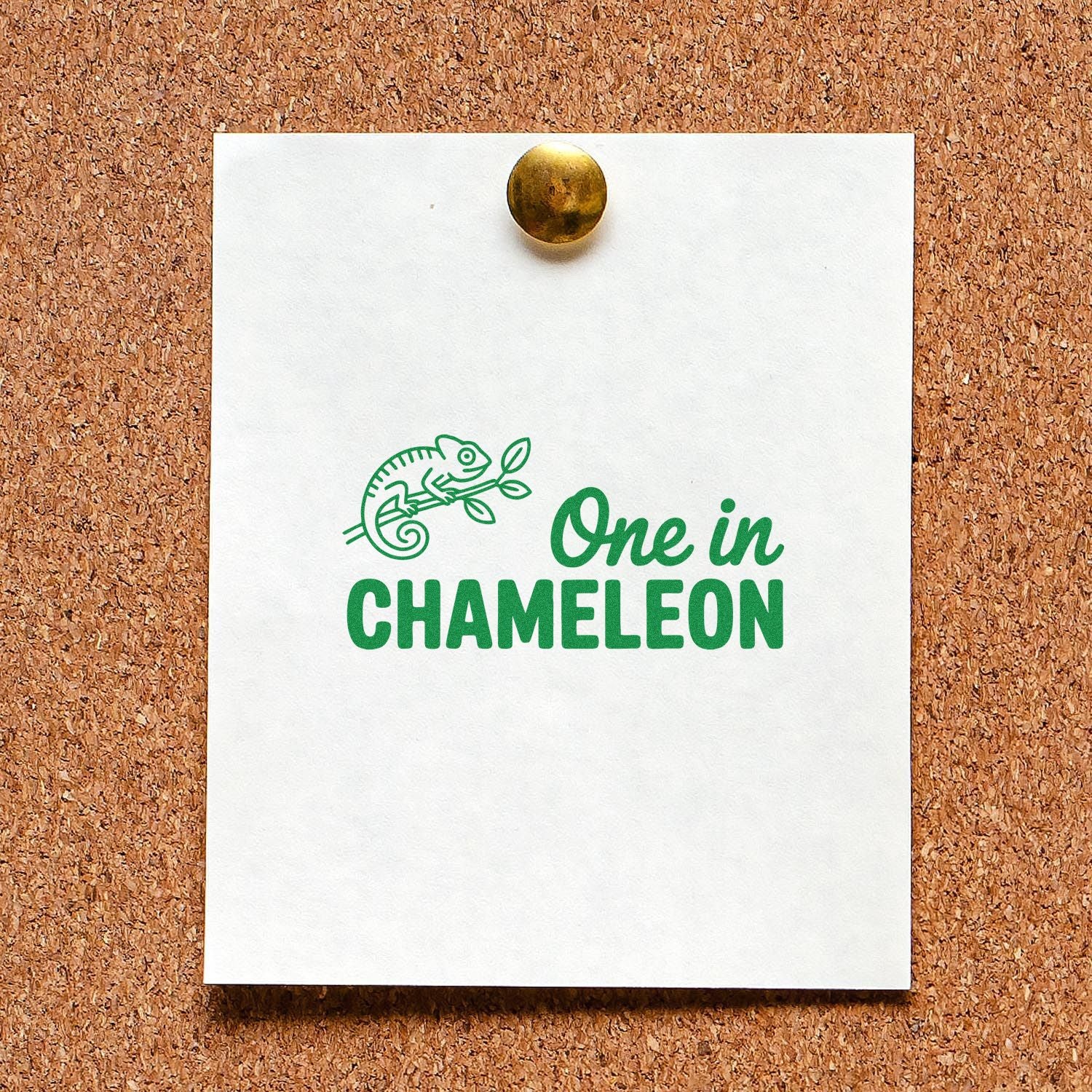 Green chameleon stamp seal on white card pinned to corkboard, with One in CHAMELEON text.