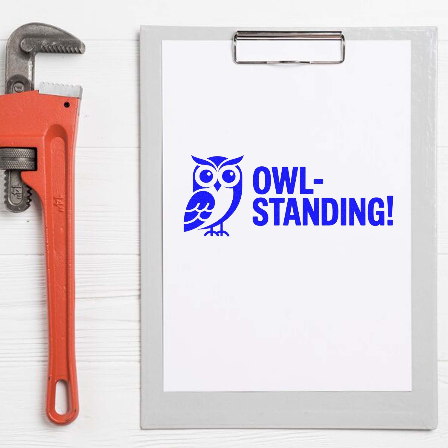 Blue owl and OWL-STANDING! stamp on clipboard beside orange pipe wrench, highlighting stamp and seal branding.
