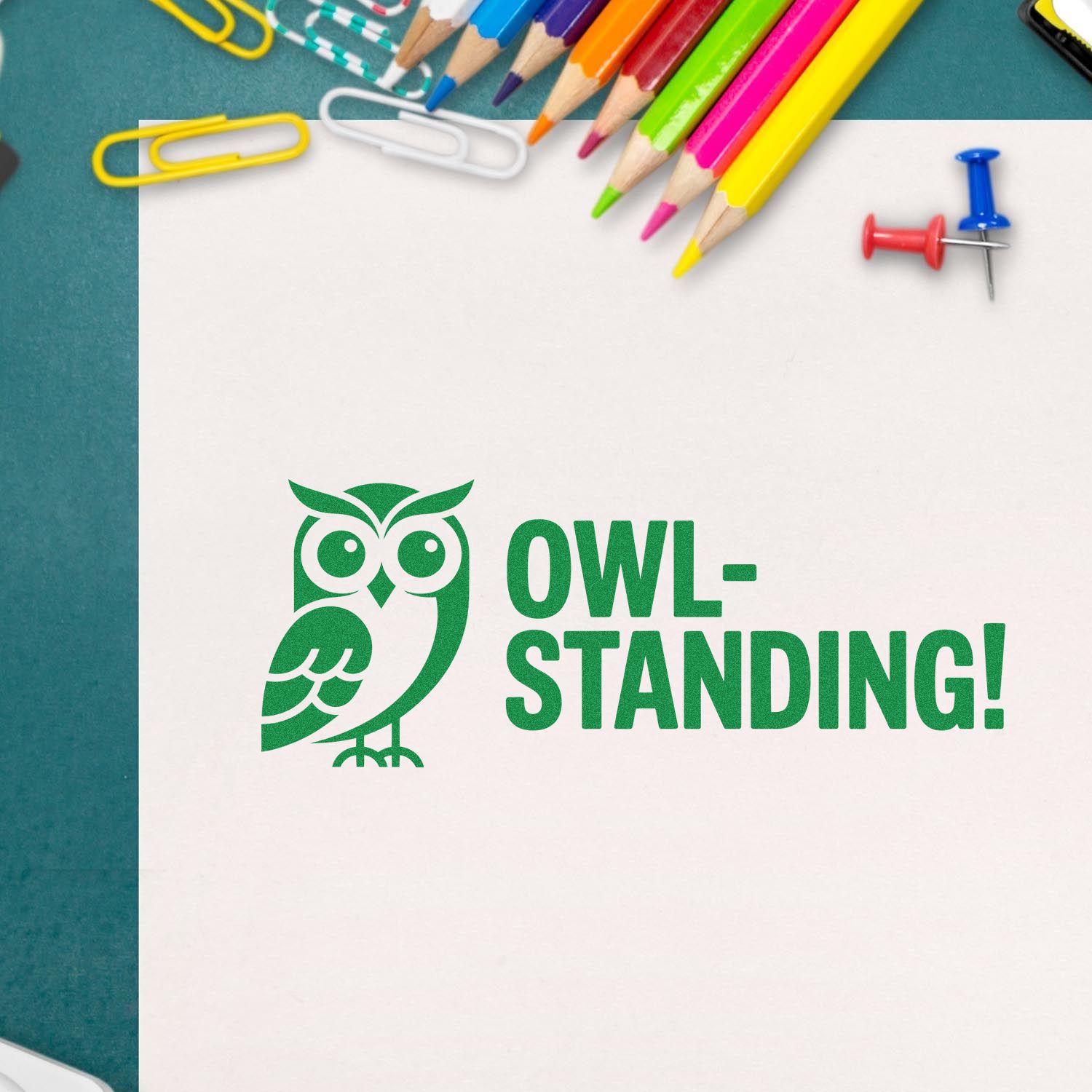 Green owl stamp and seal design reading OWL-STANDING! on white paper, surrounded by colorful pencils, paperclips, and push pins.