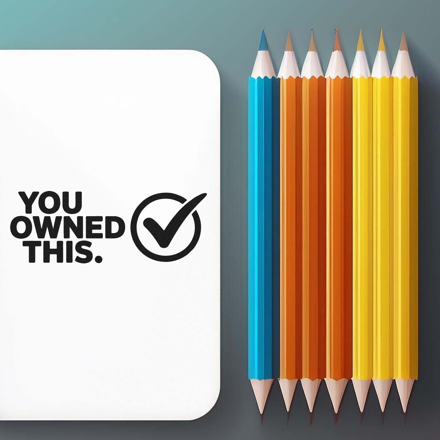 White ownership seal stamp with black checkmark and YOU OWNED THIS beside blue, orange, and yellow pencils
