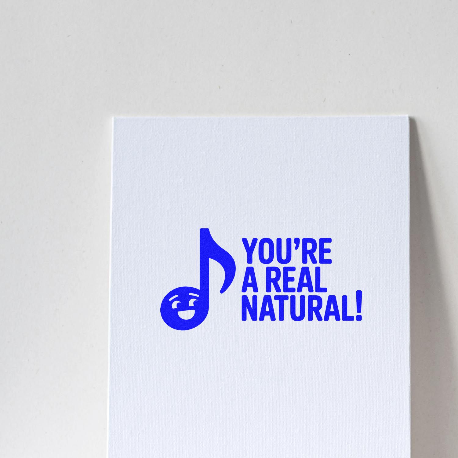 Blue custom stamp seal on white card with smiling music note and text, YOURE A REAL NATURAL!