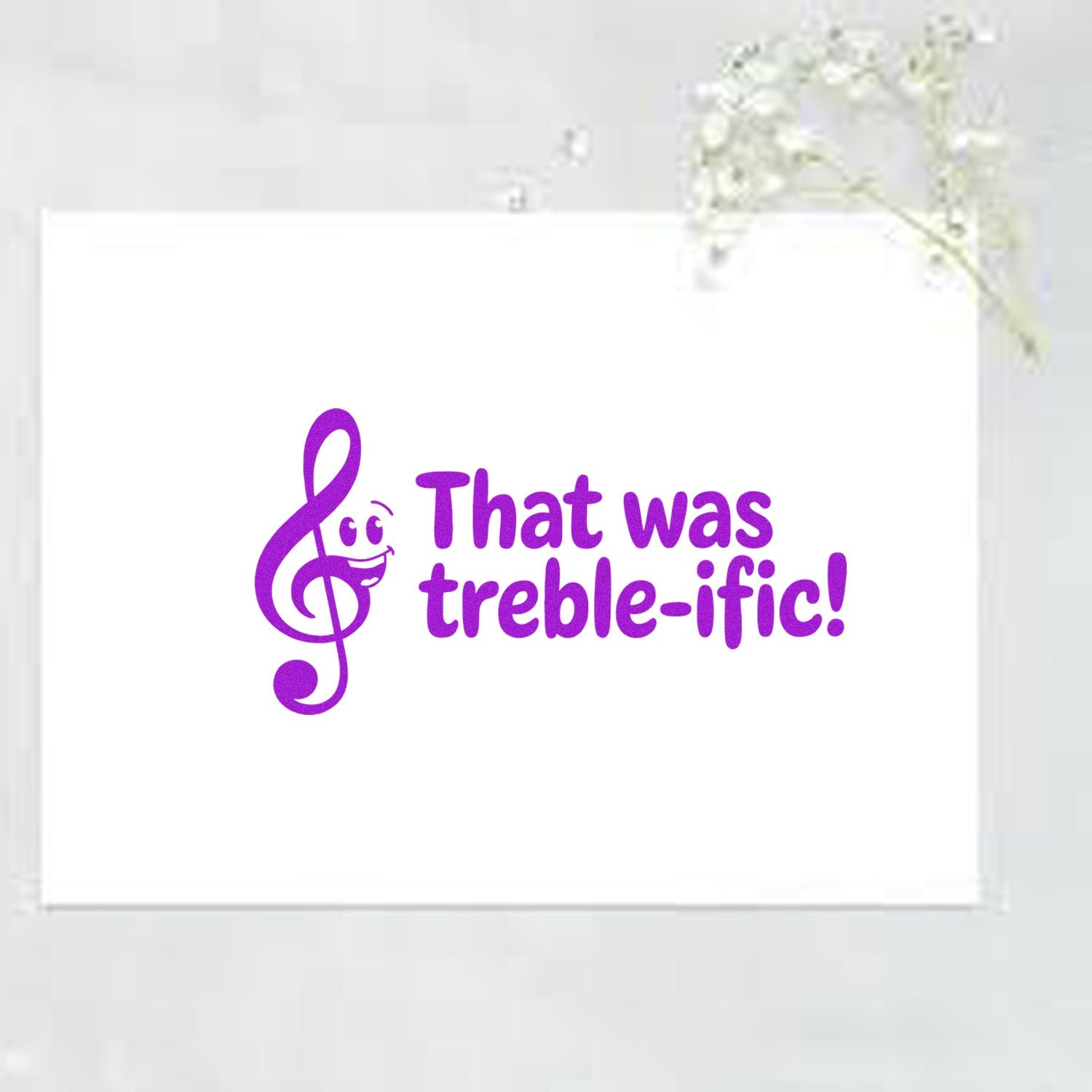 Purple musical-note stamp seal reading That was treble-ific! on a white card.
