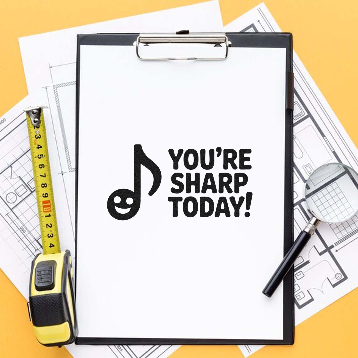 Custom stamp and seal display on clipboard with YOURE SHARP TODAY!, over blueprints, yellow tape measure, and magnifier.