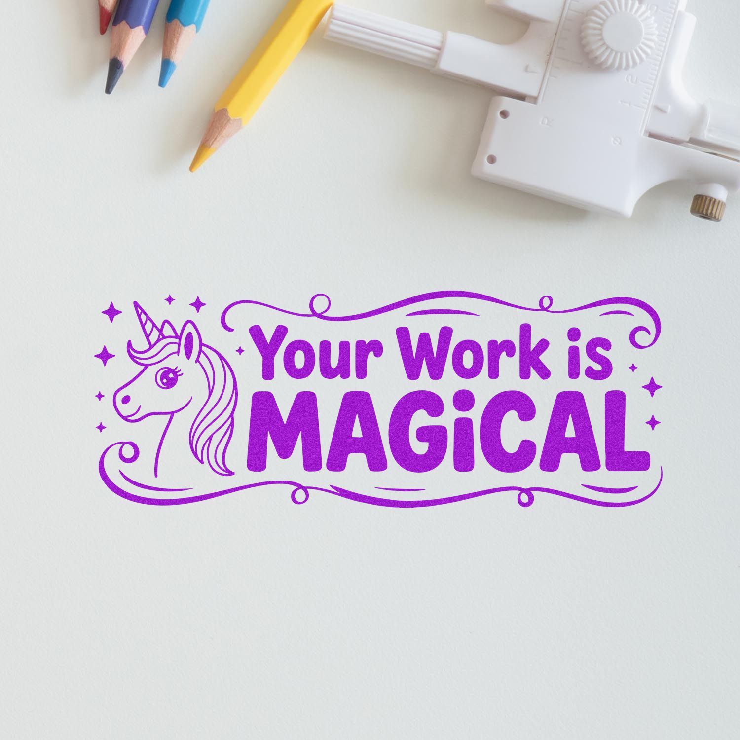 Purple unicorn stamp seal reading Your Work is Magical with pastel pencils and a white embossing tool.