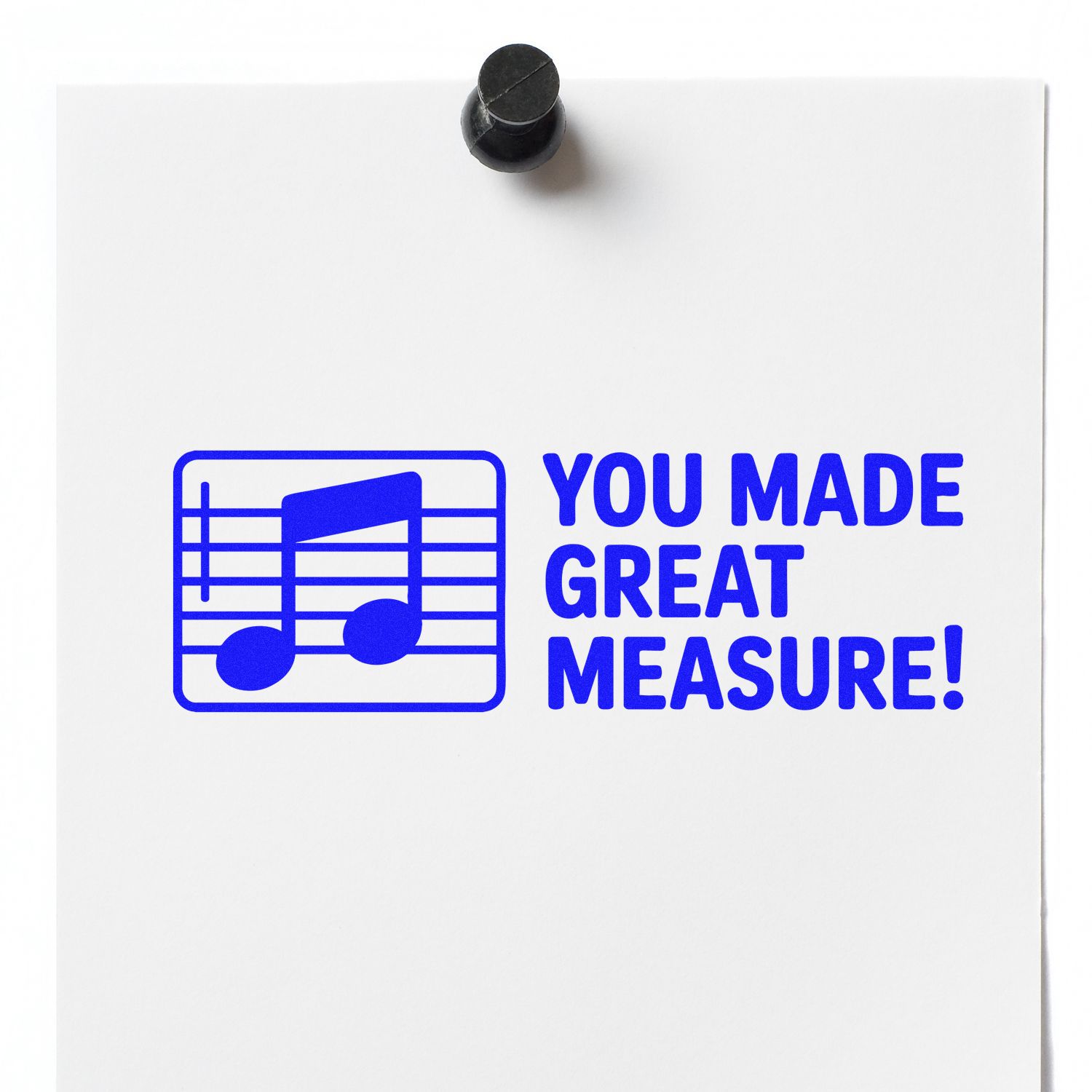Blue rubber stamp seal on white paper with music note icon, reading You Made Great Measure! pinned with black tack.