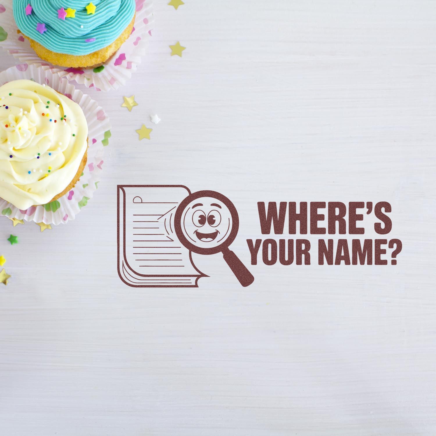 Brown custom stamp and seal with magnifying glass logo and Wheres Your Name? on white wood, beside pastel cupcakes.