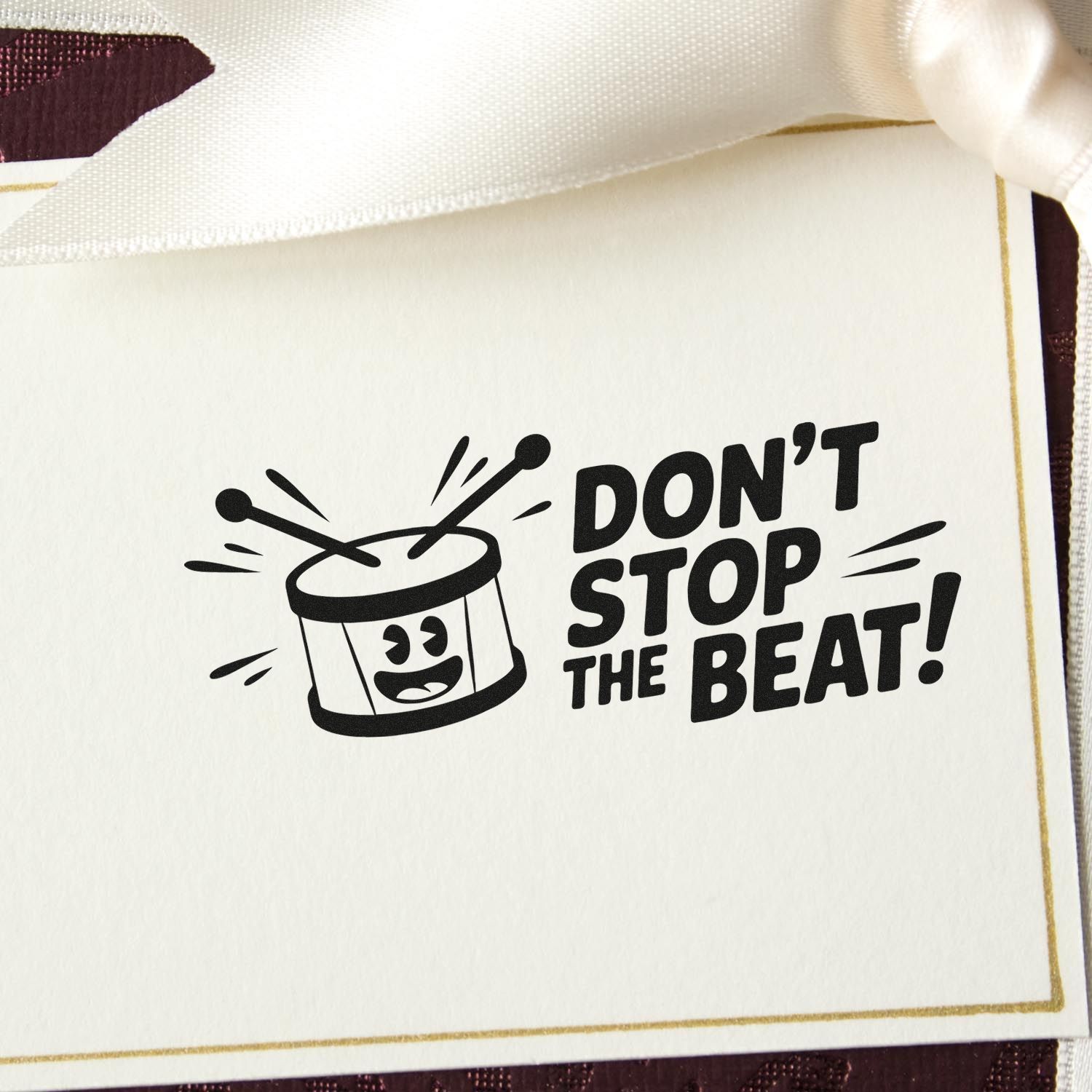 Black custom stamp seal with drum icon on cream card, reading DONT STOP THE BEAT!