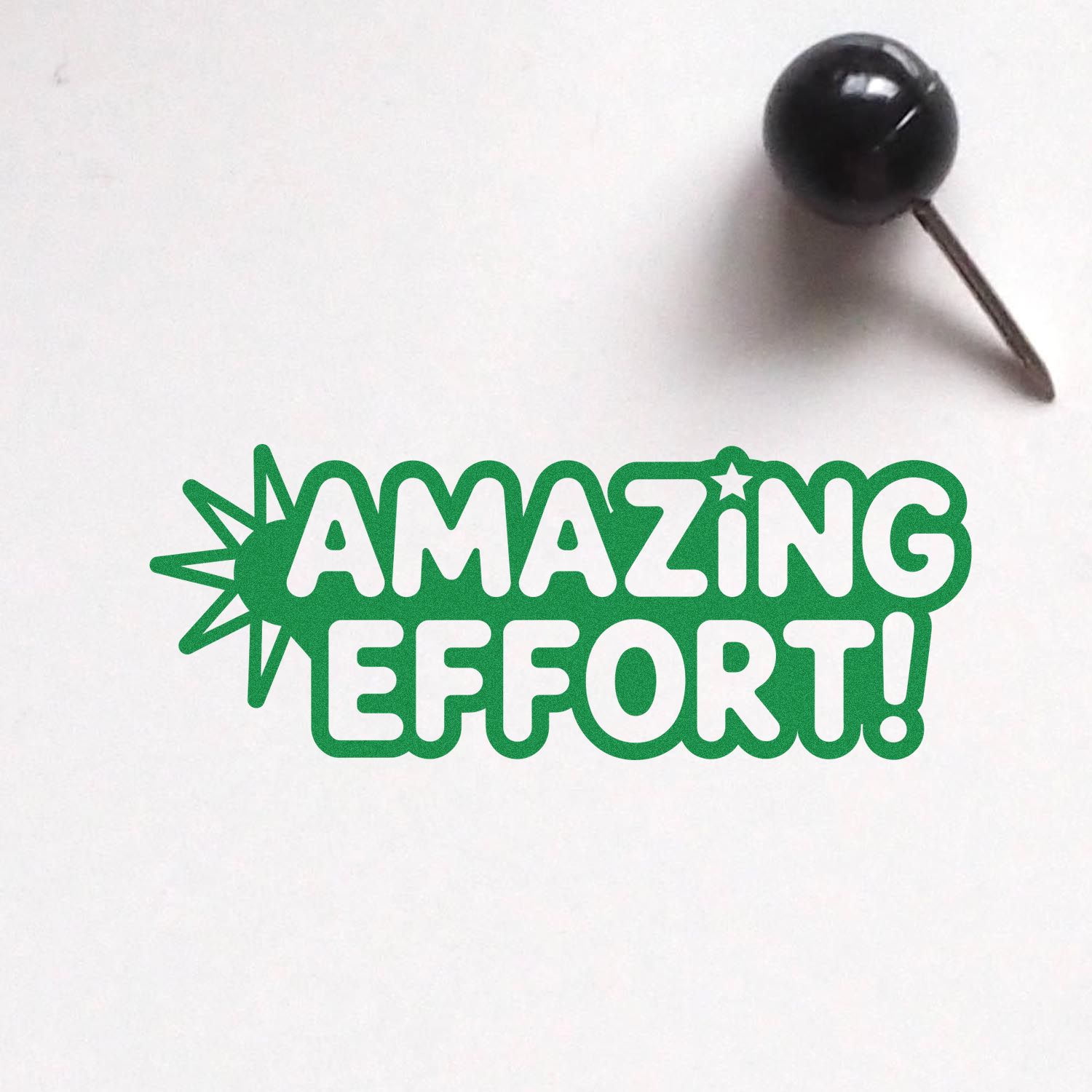 Green AMAZING EFFORT! stamp and black pushpin seal on white background, with starburst accent.