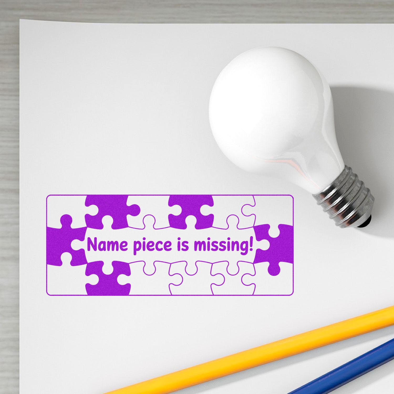White lightbulb stamp with purple puzzle-piece seal reading Name piece is missing! on white paper