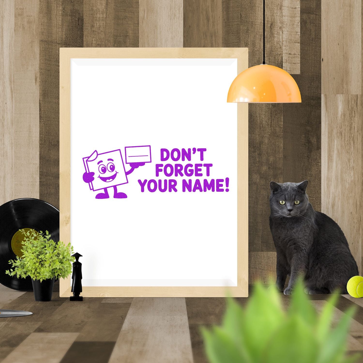 Purple stamp and seal design reading DONT FORGET YOUR NAME! with cartoon mascot on a white framed display.