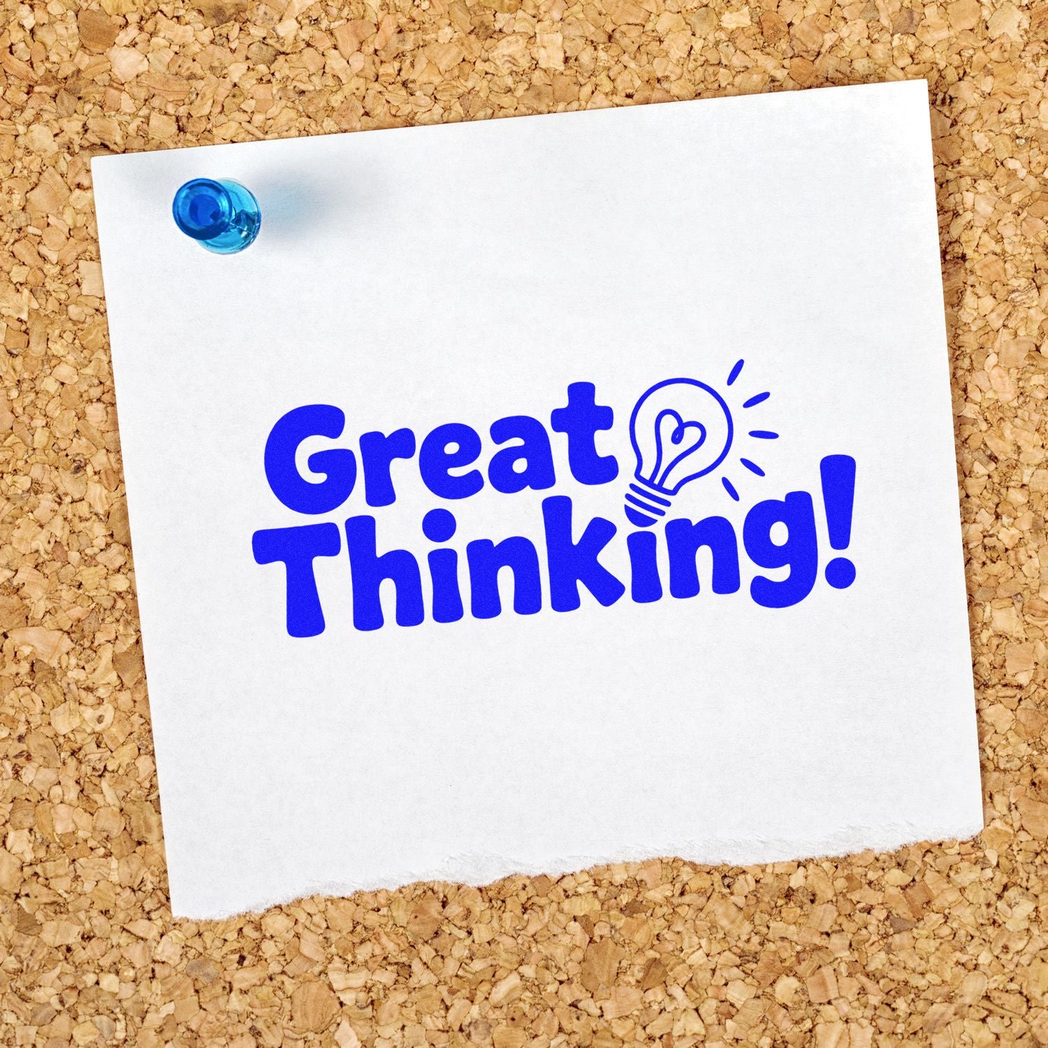 Blue rubber stamp/seal reading "Great Thinking!" with lightbulb icon on white paper pinned to a corkboard.