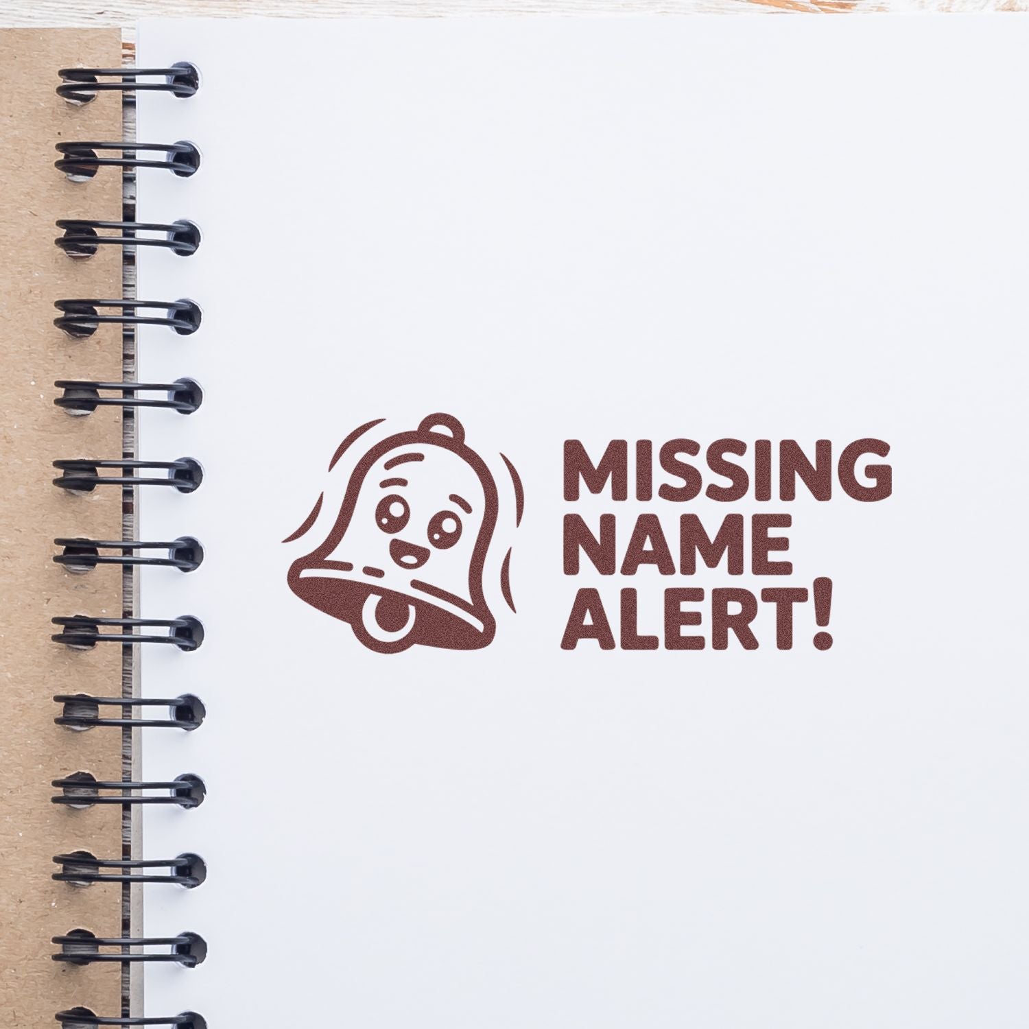 Brown rubber stamp reading MISSING NAME ALERT! with a bell icon on white notebook paper.