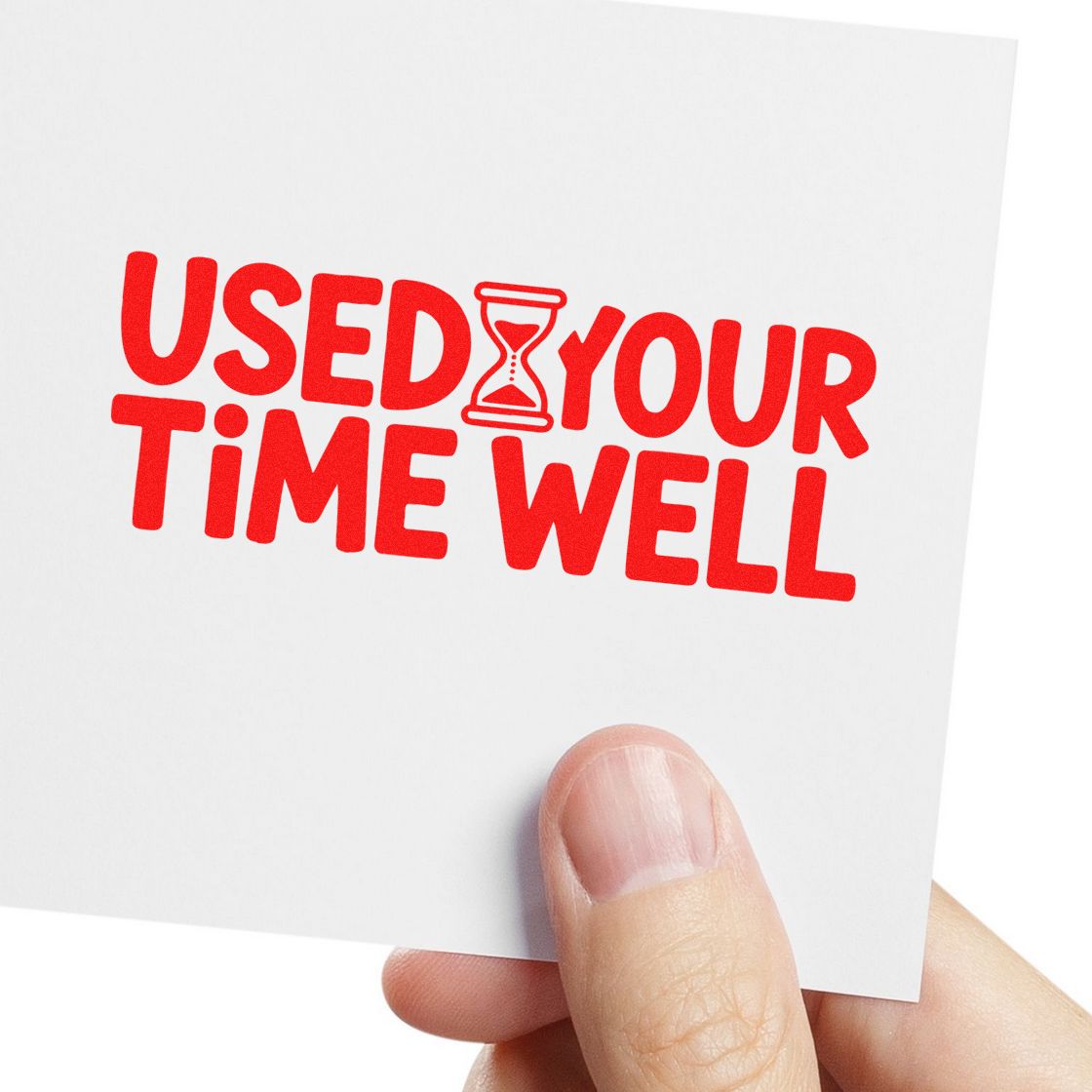 Red rubber stamp reading USED YOUR TIME WELL with hourglass icon on white card, held by hand.