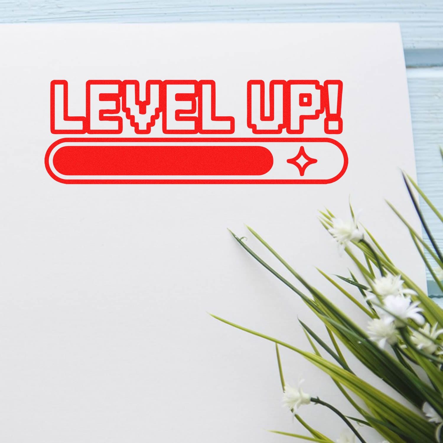Red LEVEL UP! stamp seal design on white card, with progress bar icon and green floral accents
