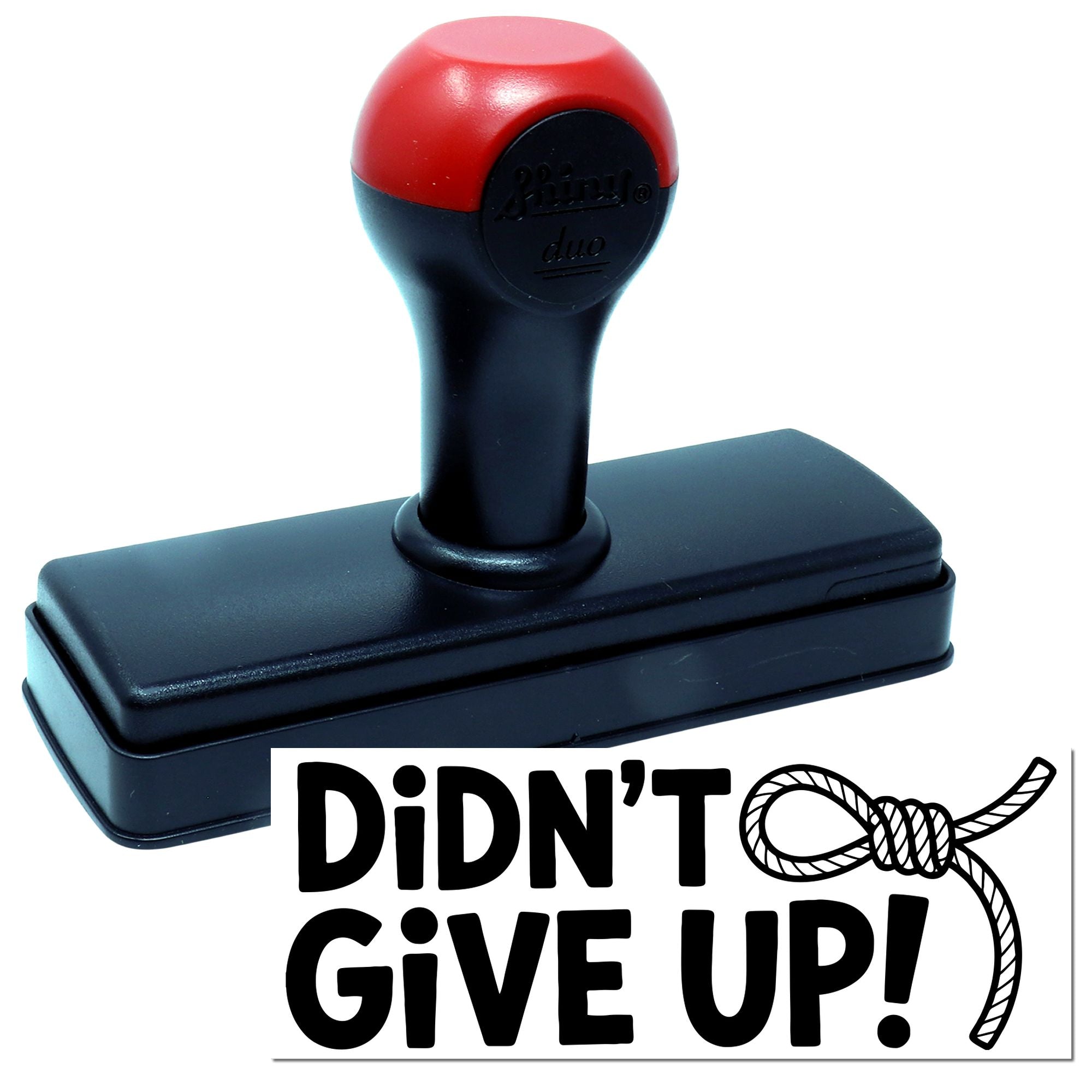 Black self-inking stamp with red handle and DIDNT GIVE UP! rope-style seal text.
