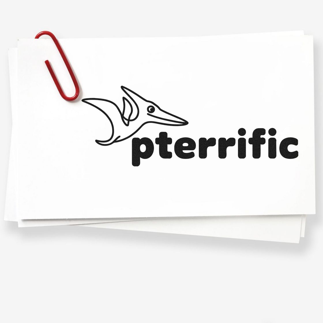 Custom stamp and seal cards with black pterrific pterodactyl logo, stacked on white paper and clipped with a red paperclip.