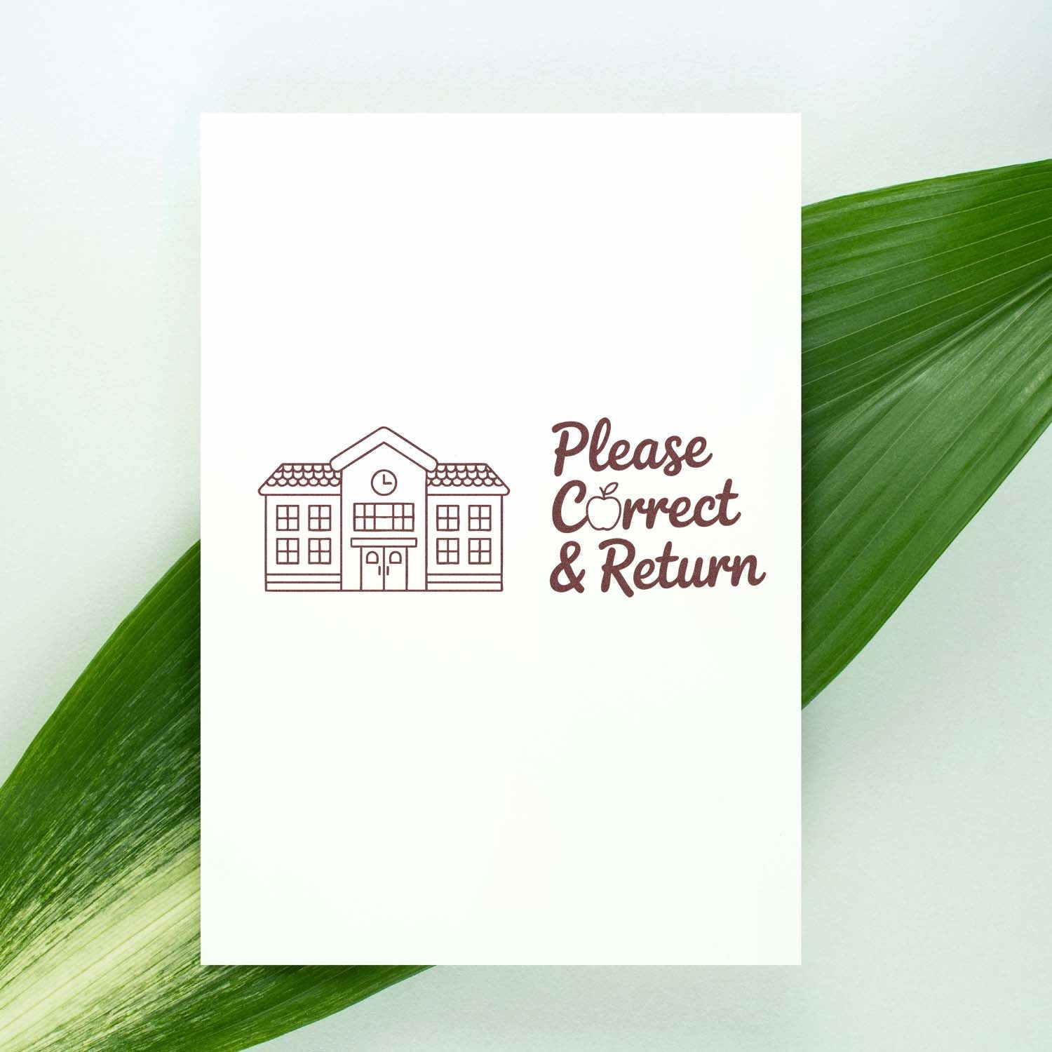 Brown Please Correct & Return return-address stamp with house icon on white card, against green leaf background.