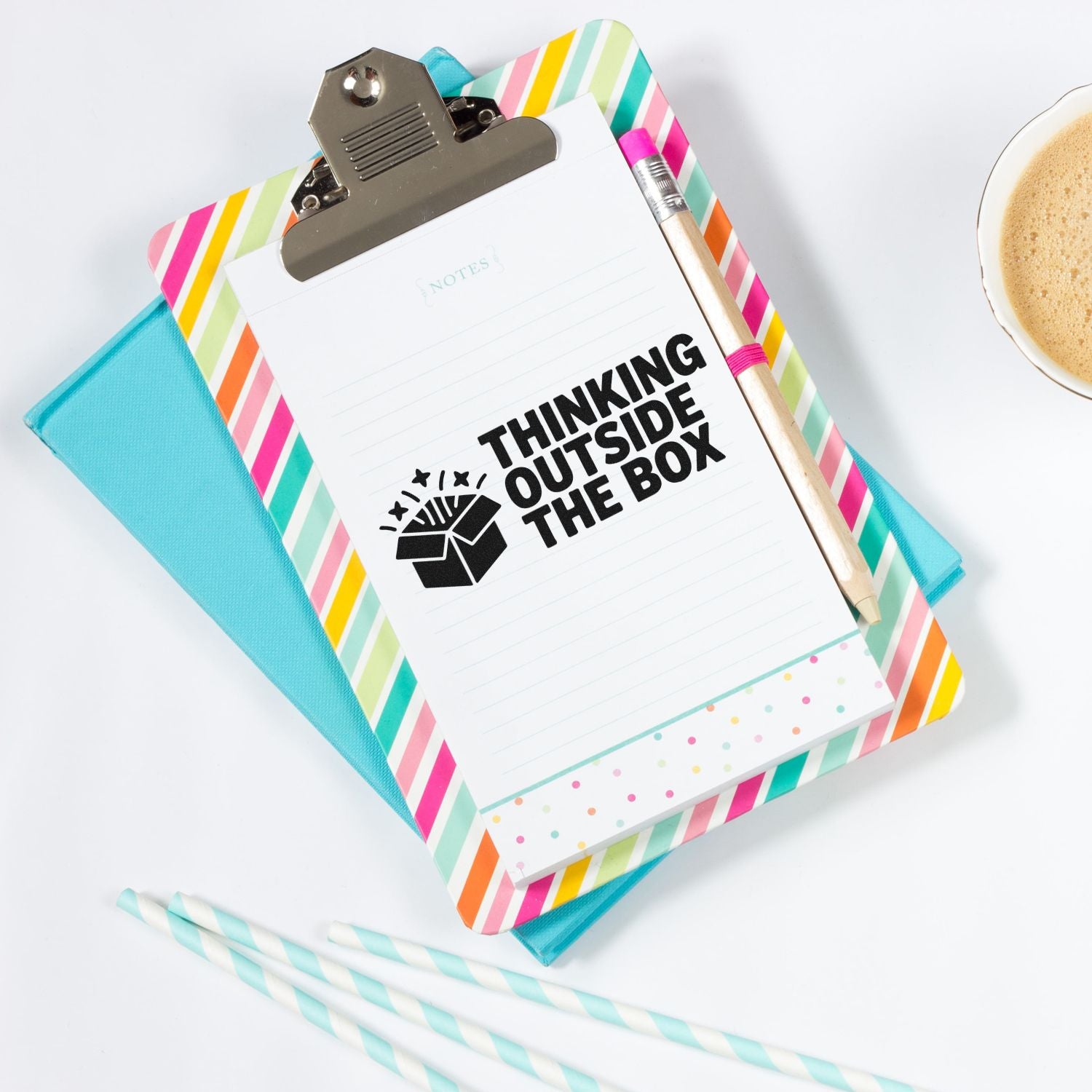 Colorful stamp and seal stationery set with clipboard notepad, black Thinking Outside the Box stamp, pencil, and striped notebook