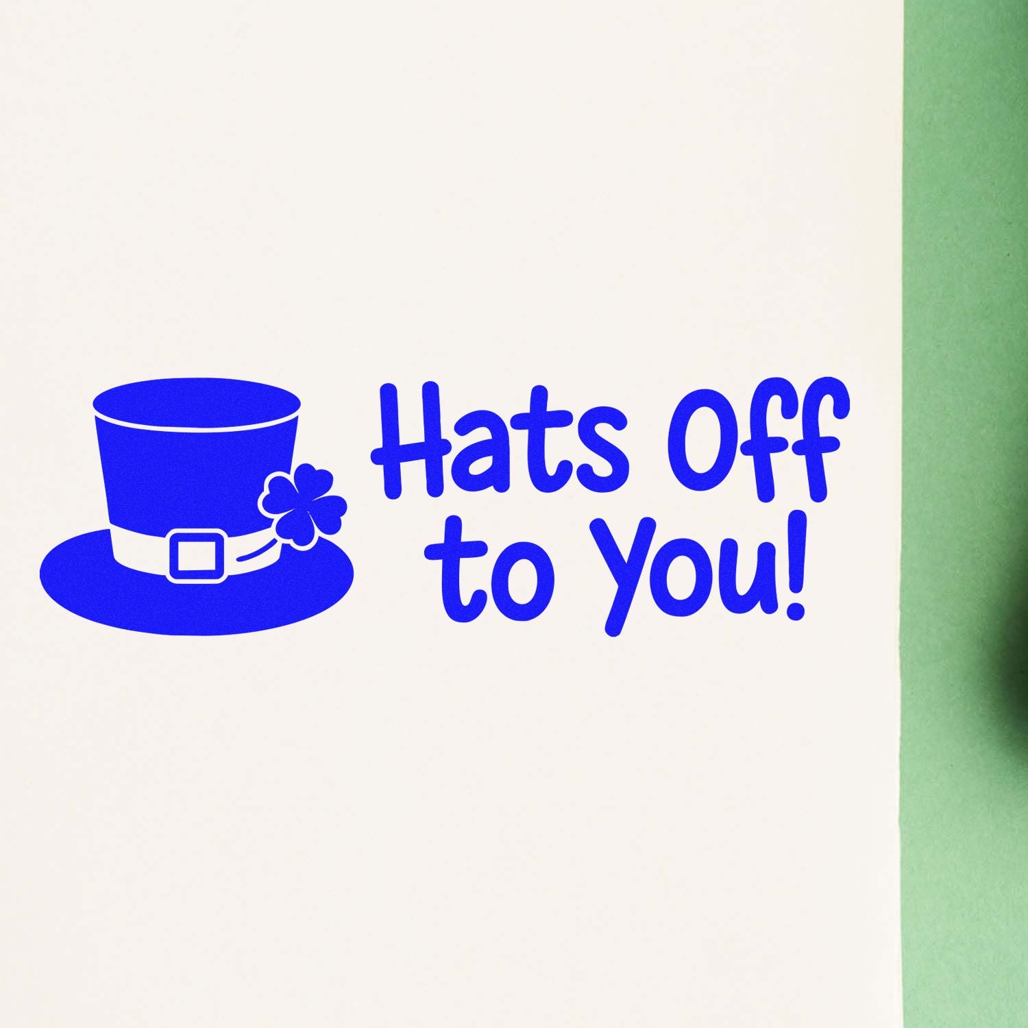 Blue stamp and seal design with top hat, shamrock, and Hats Off to You! on a white background.