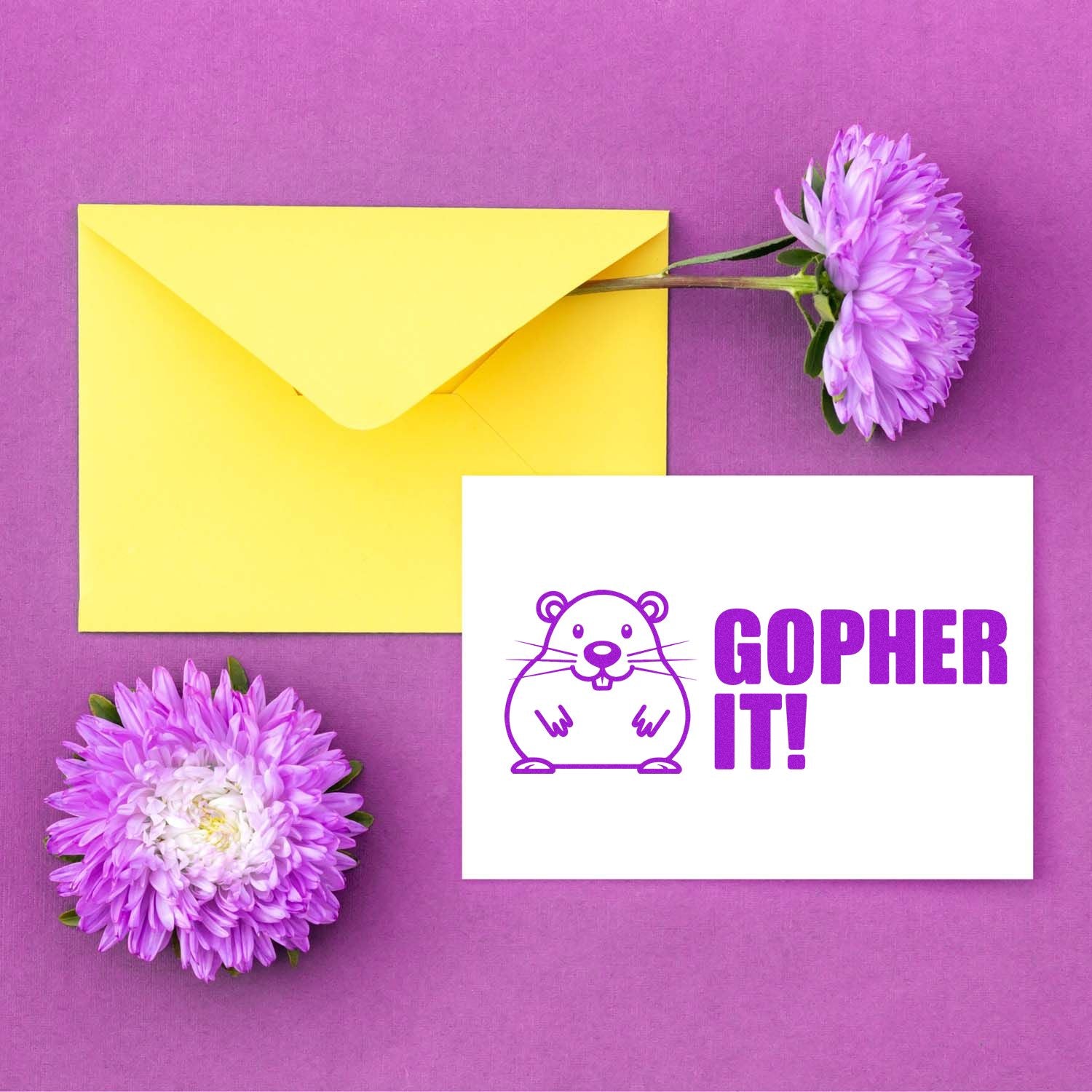 Yellow envelope with purple flowers and white stamp card reading GOPHER IT! with purple gopher seal design.