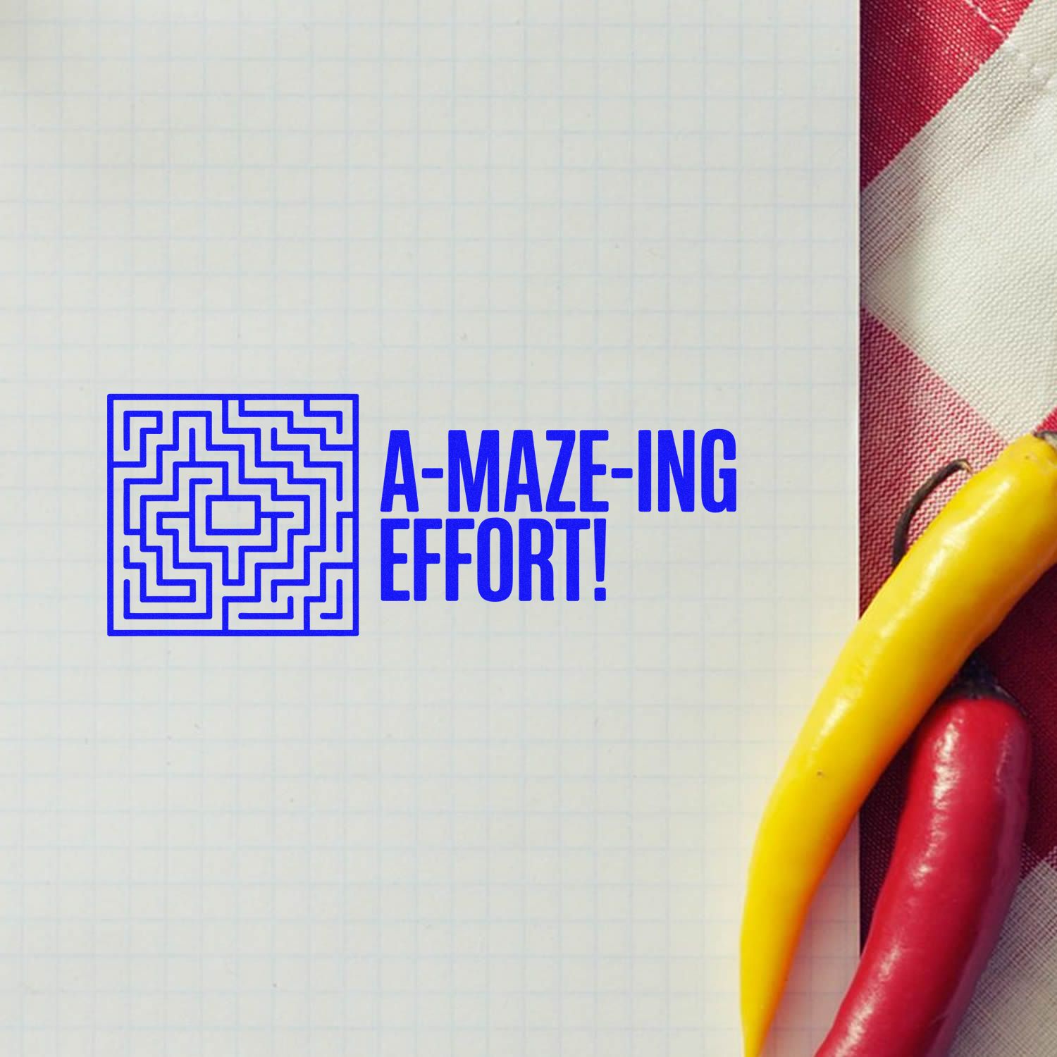 Blue maze stamp reading A-MAZE-ING EFFORT! on graph paper, beside red and yellow sealing wax sticks.