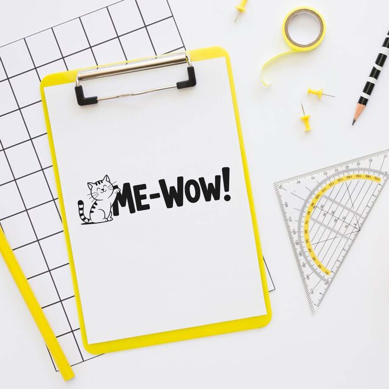 Yellow-framed clipboard displaying ME-WOW cat stamp, with grid paper, ruler, pencil, and yellow stamp and seal tools.