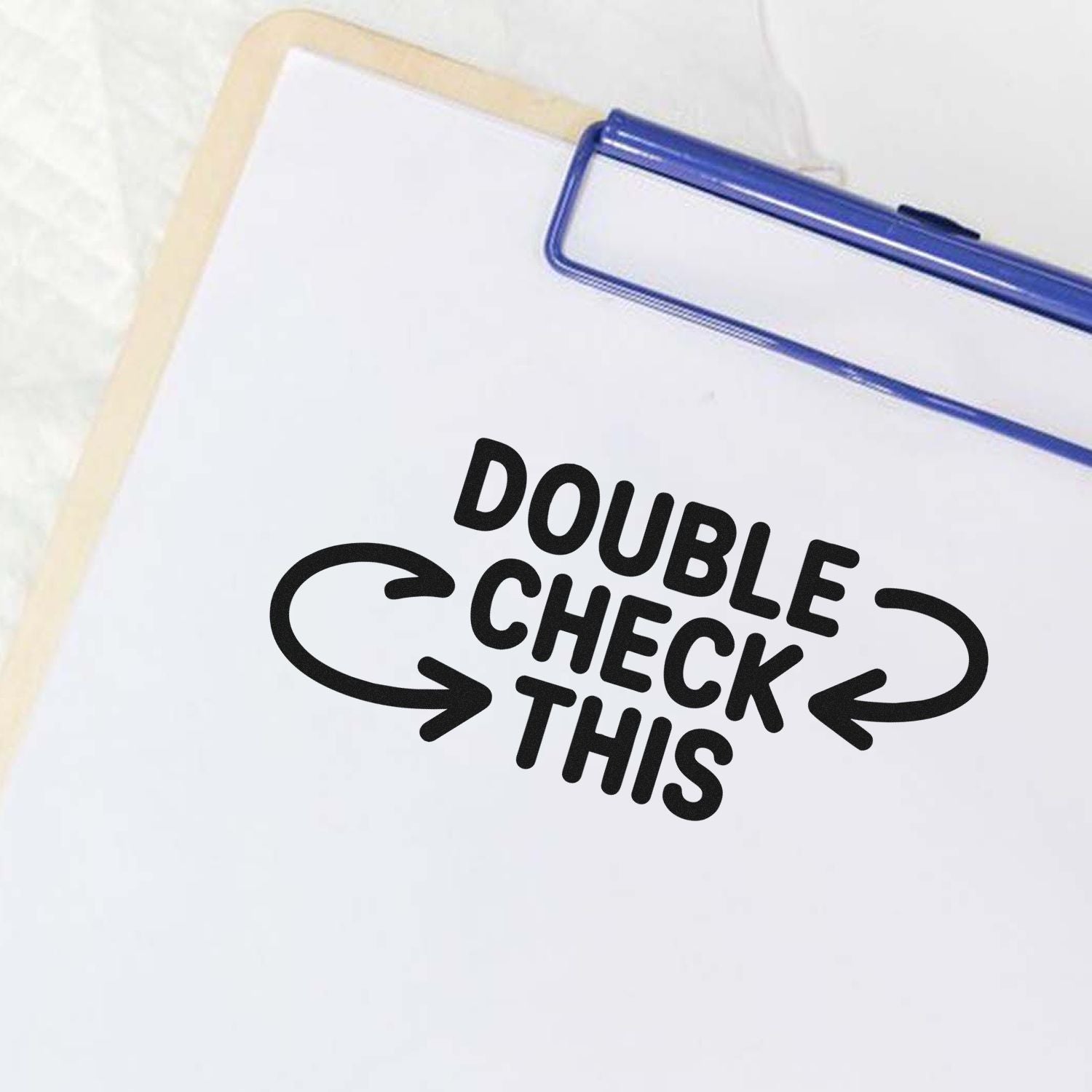 Blue self-inking stamp and seal on white paper with bold black DOUBLE CHECK THIS text and arrows.