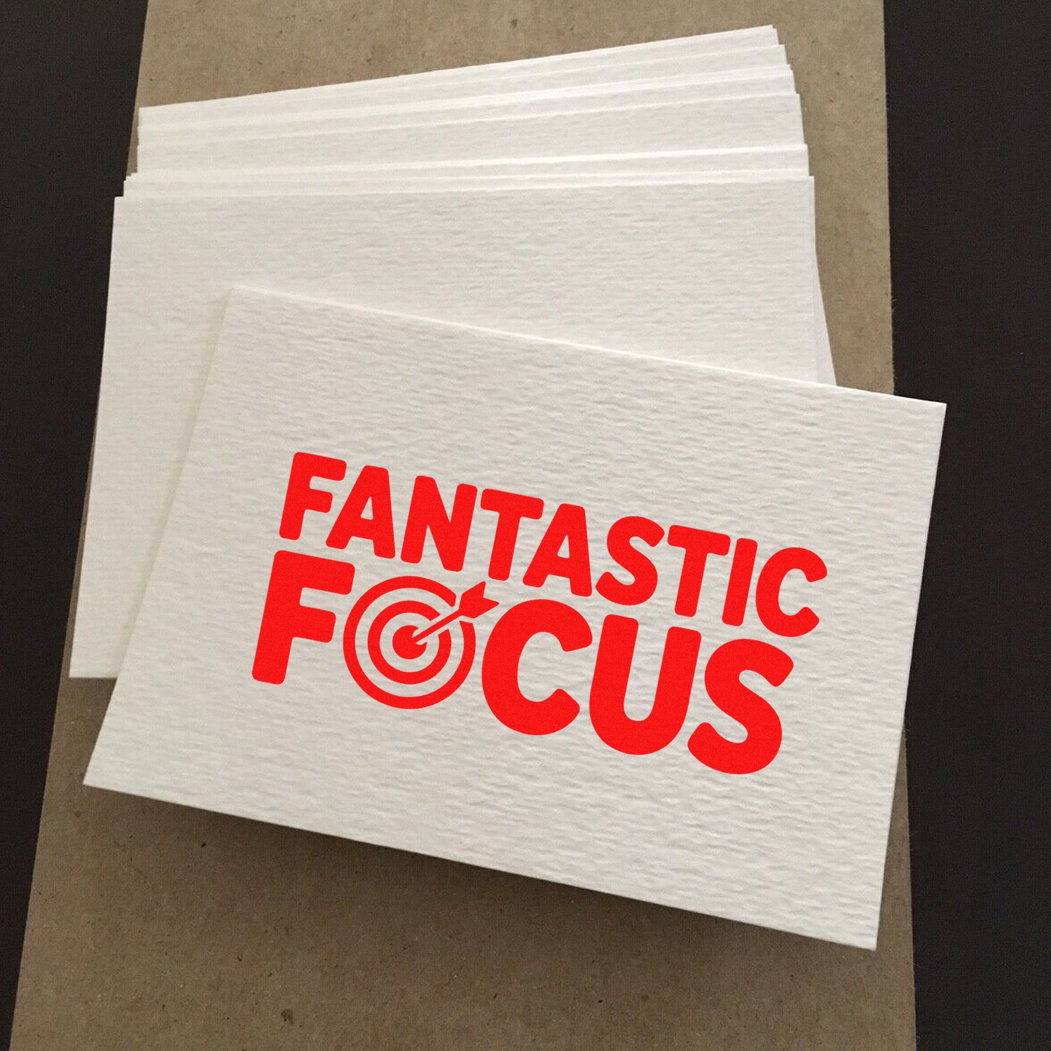 Stacked white stamp and seal sheets with red FANTASTIC FOCUS logo and target icon.