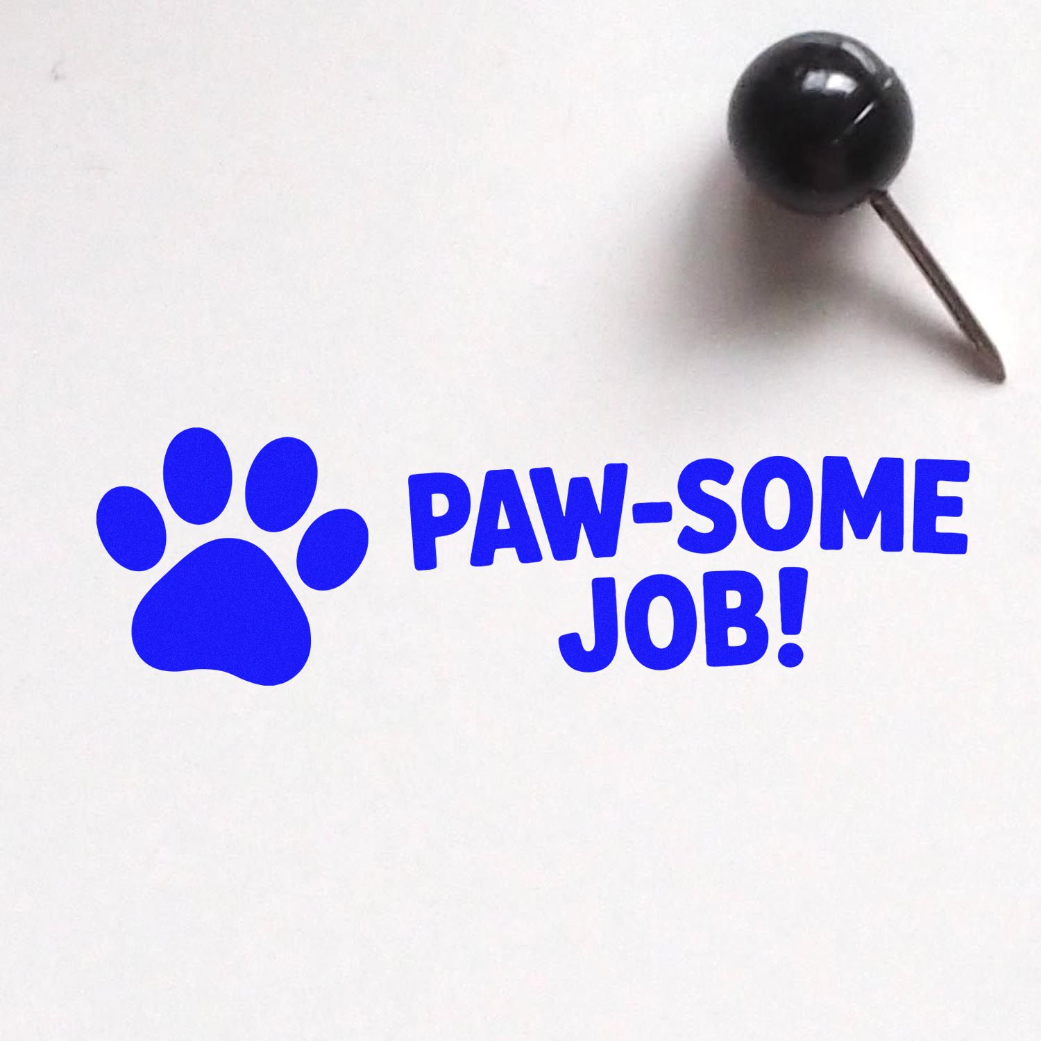 Blue paw-print stamp and seal reading PAW-SOME JOB! with black handle on white background.