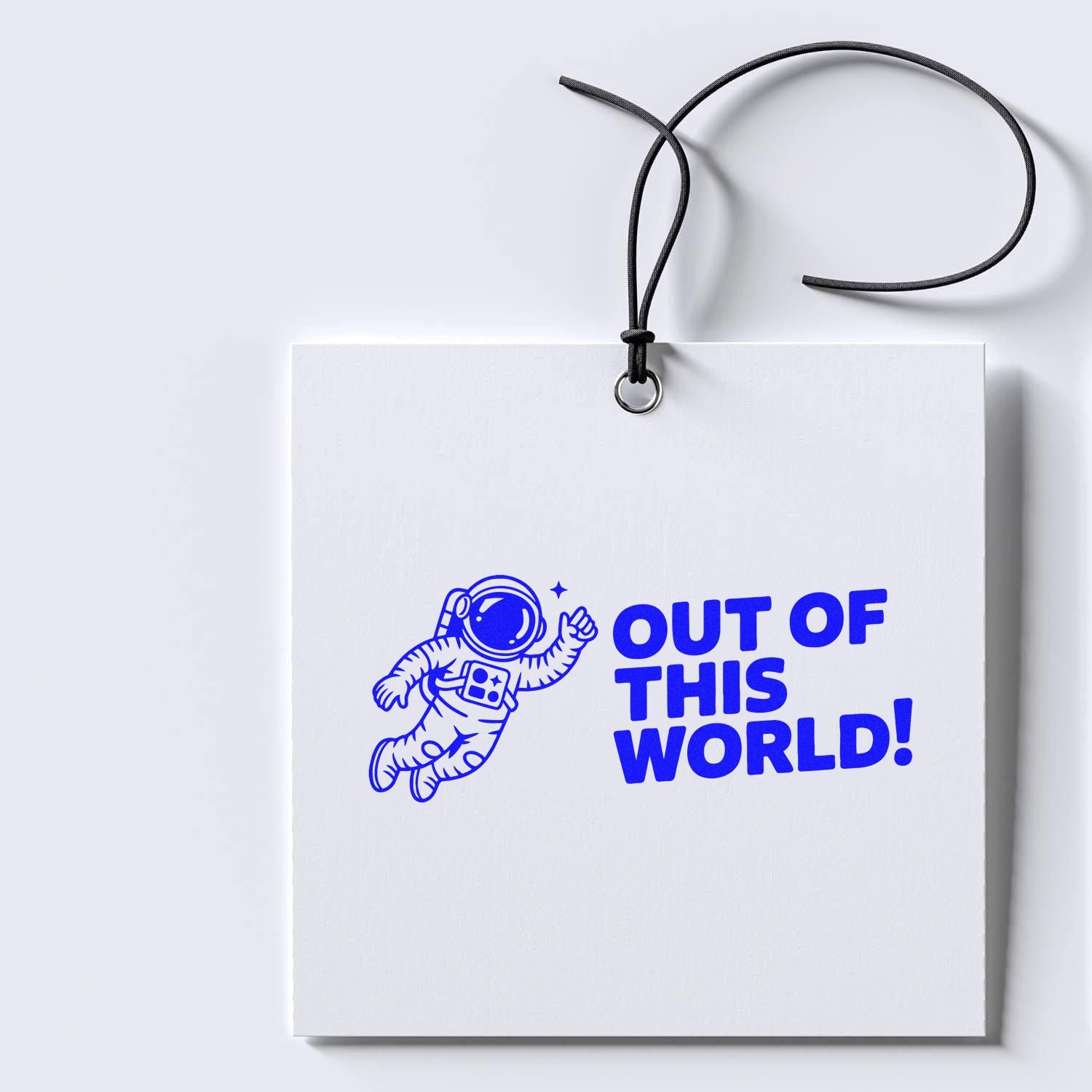White hanging stamp seal tag with black cord, blue astronaut, and bold OUT OF THIS WORLD! in bright blue.