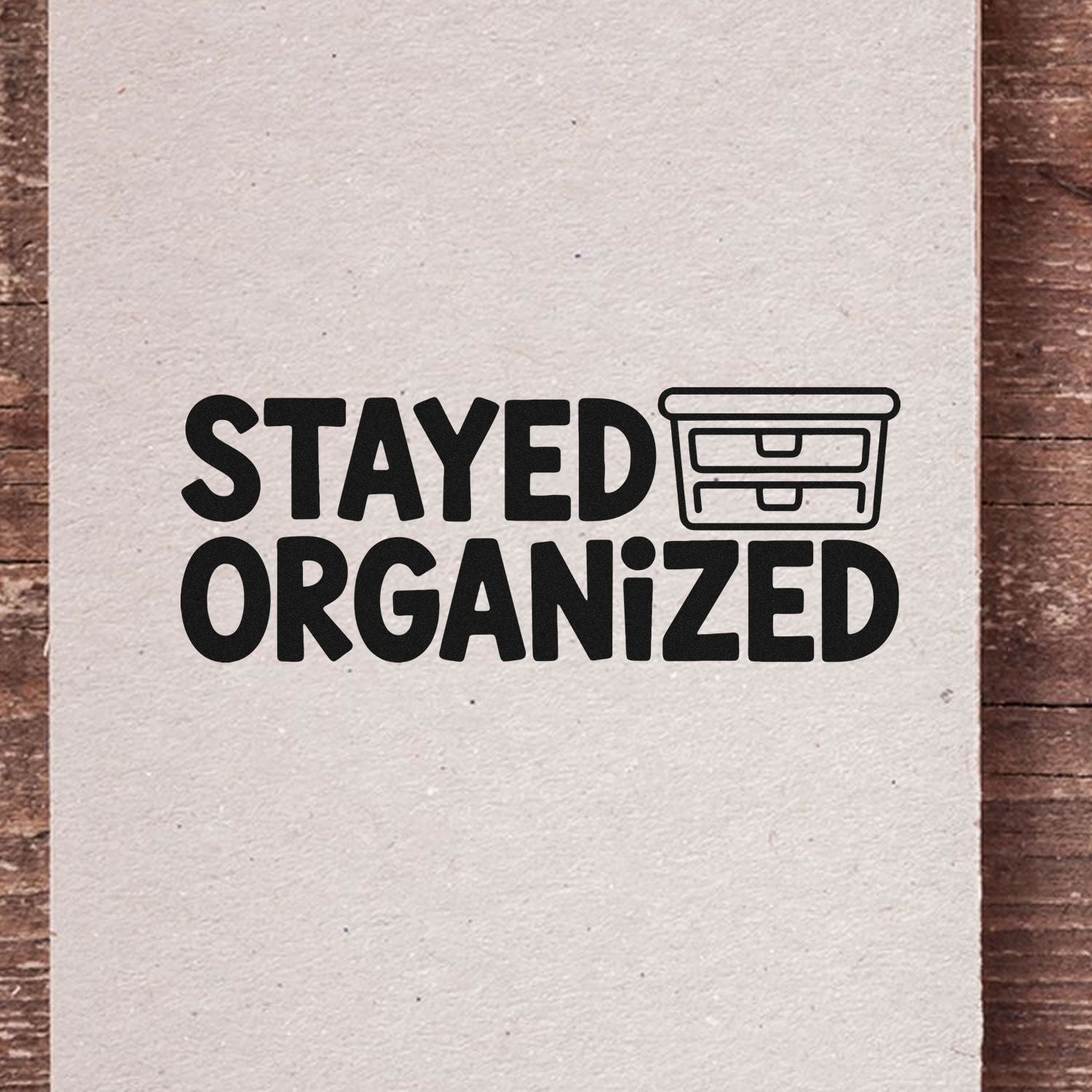 Black custom stamp reading STAYED ORGANIZED with drawer icon on beige paper, for stamp and seal products.