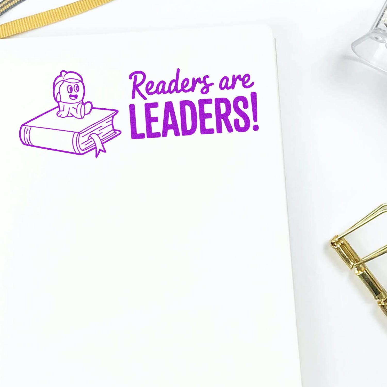 Purple stamp seal reading Readers are LEADERS! with book and child icon on white paper.