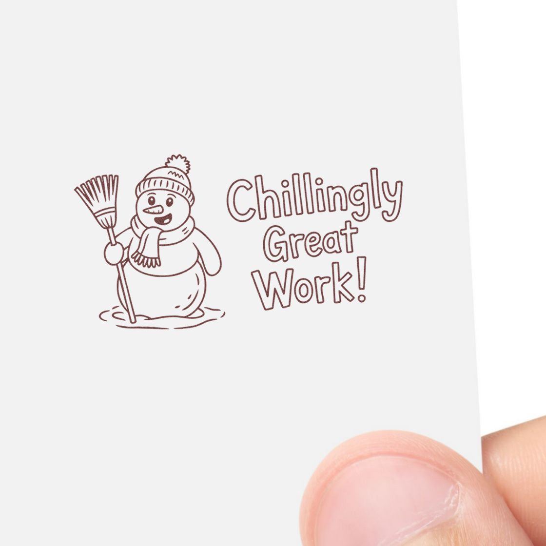 Brown stamp seal with snowman holding a broom and Chillingly Great Work! on white paper.