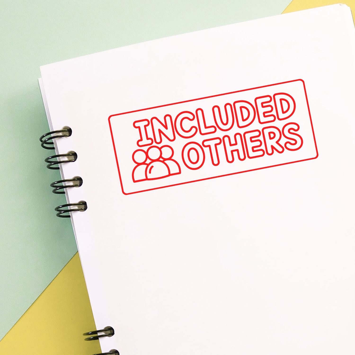 Red Included Others stamp seal on a white spiral notebook, with pastel green and yellow background.