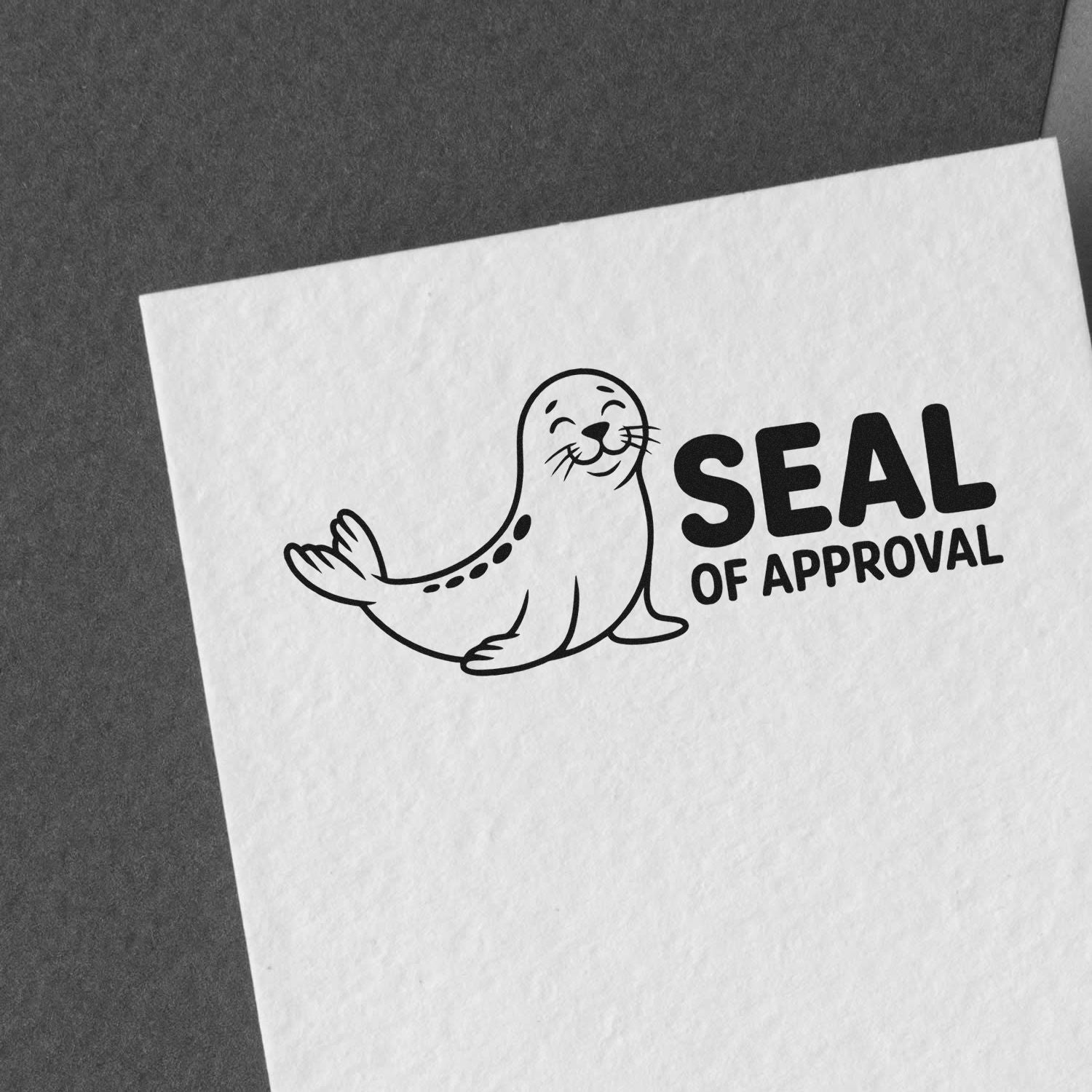 Black seal of approval rubber stamp with smiling seal on white paper against dark gray background.