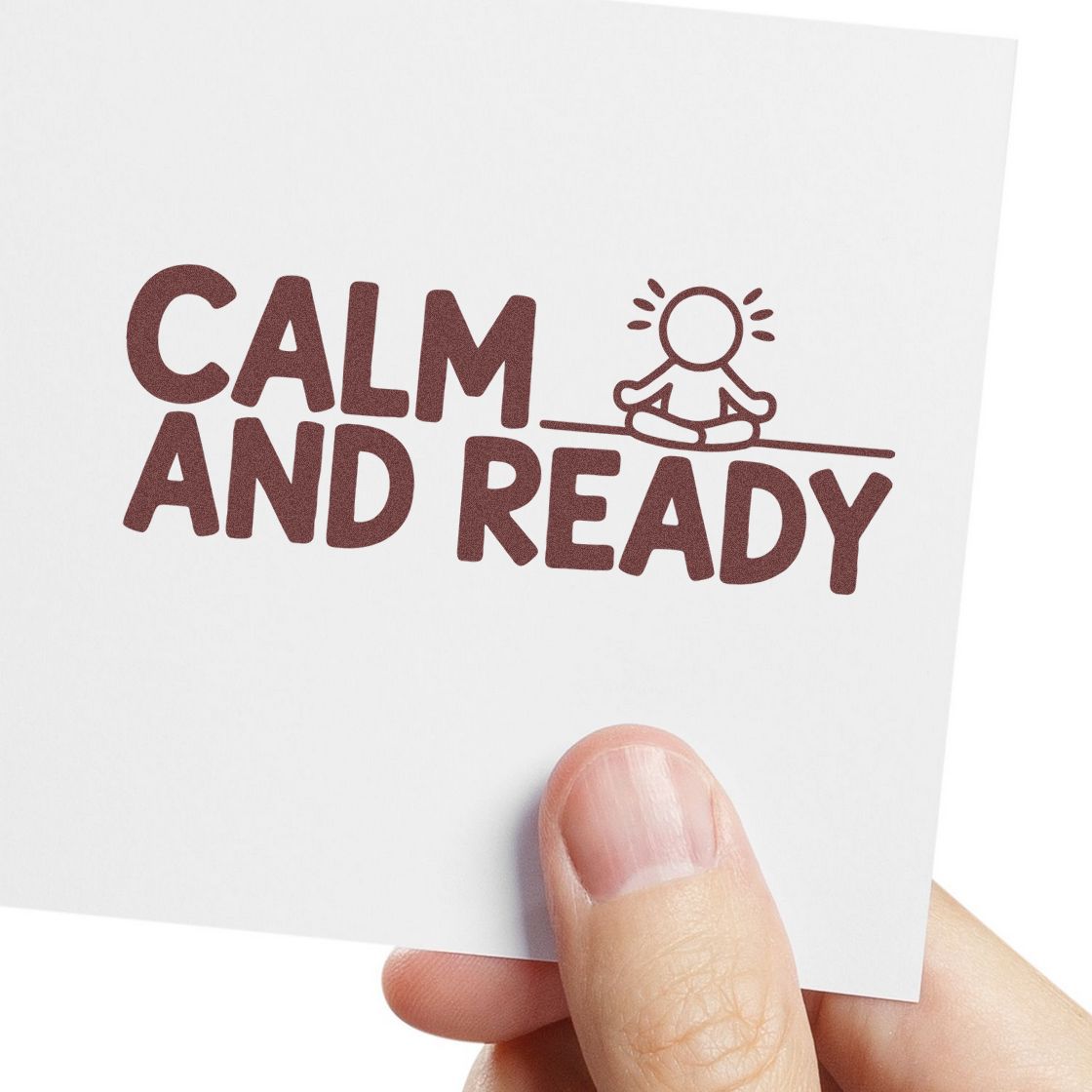 Brown CALM AND READY stamp seal on white card, with meditating figure icon, held by a hand.