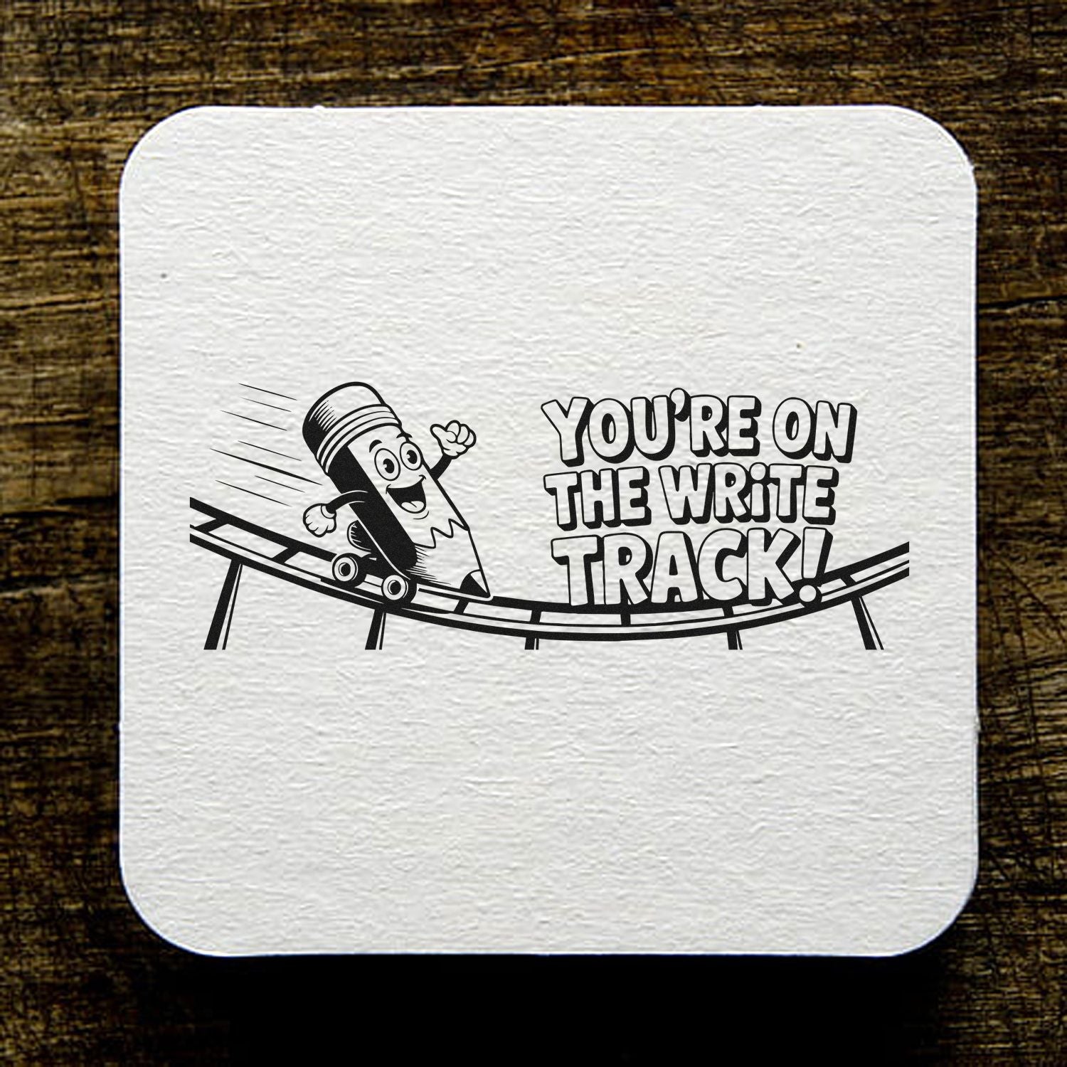 Black custom stamp seal with cartoon pencil skateboarding on a track and bold text, Youre on the write track! on white textured square.