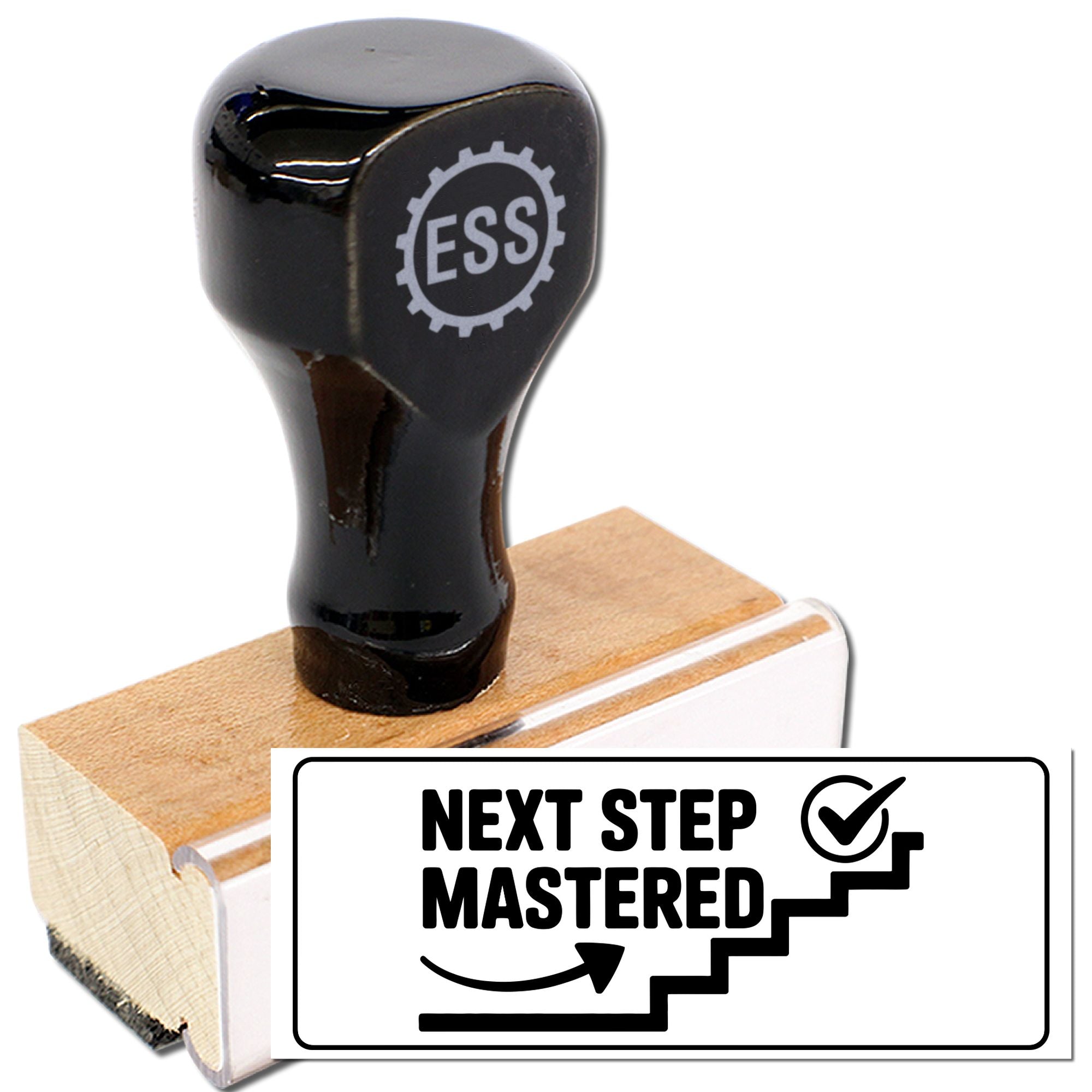 Black ESS rubber stamp and seal on wooden block, with Next Step Mastered imprint.