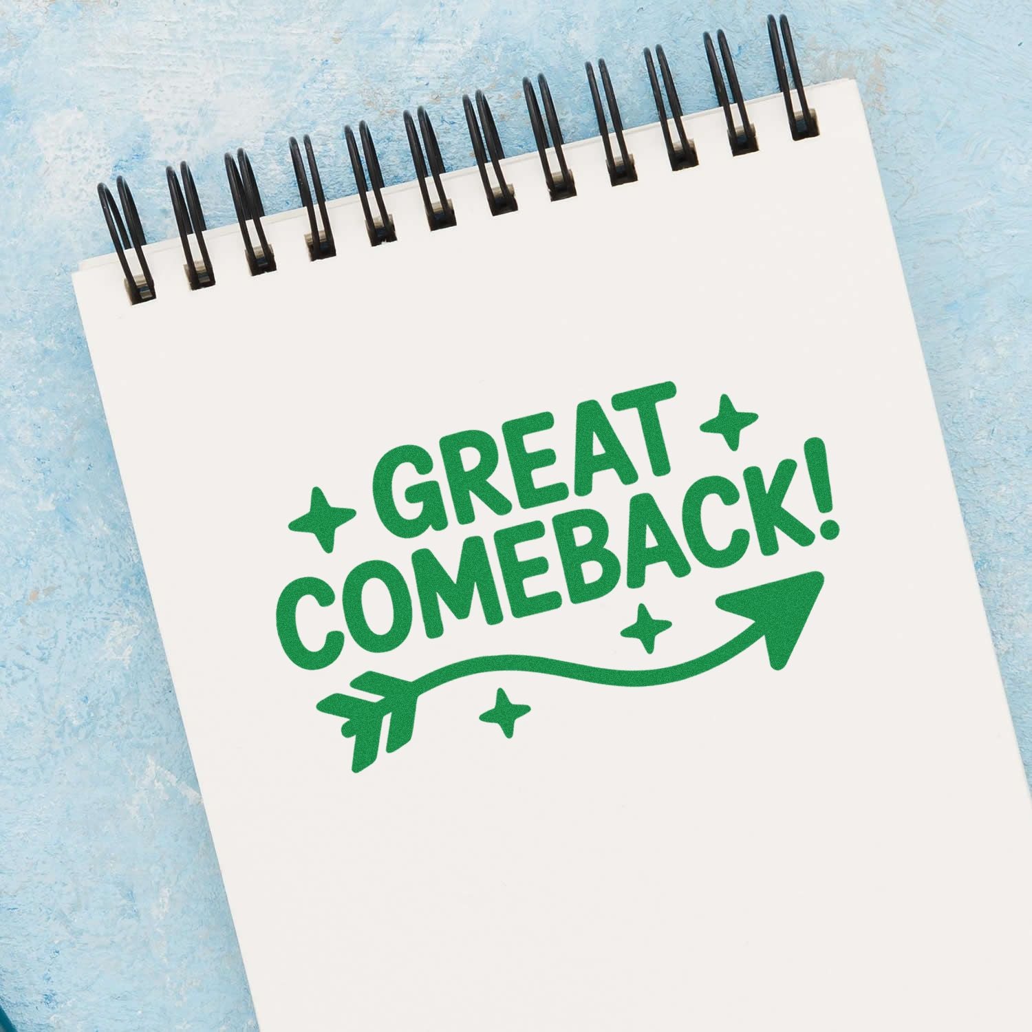 Green Great Comeback! stamp and seal design on a white spiral notebook page with arrow and stars, on a blue background.