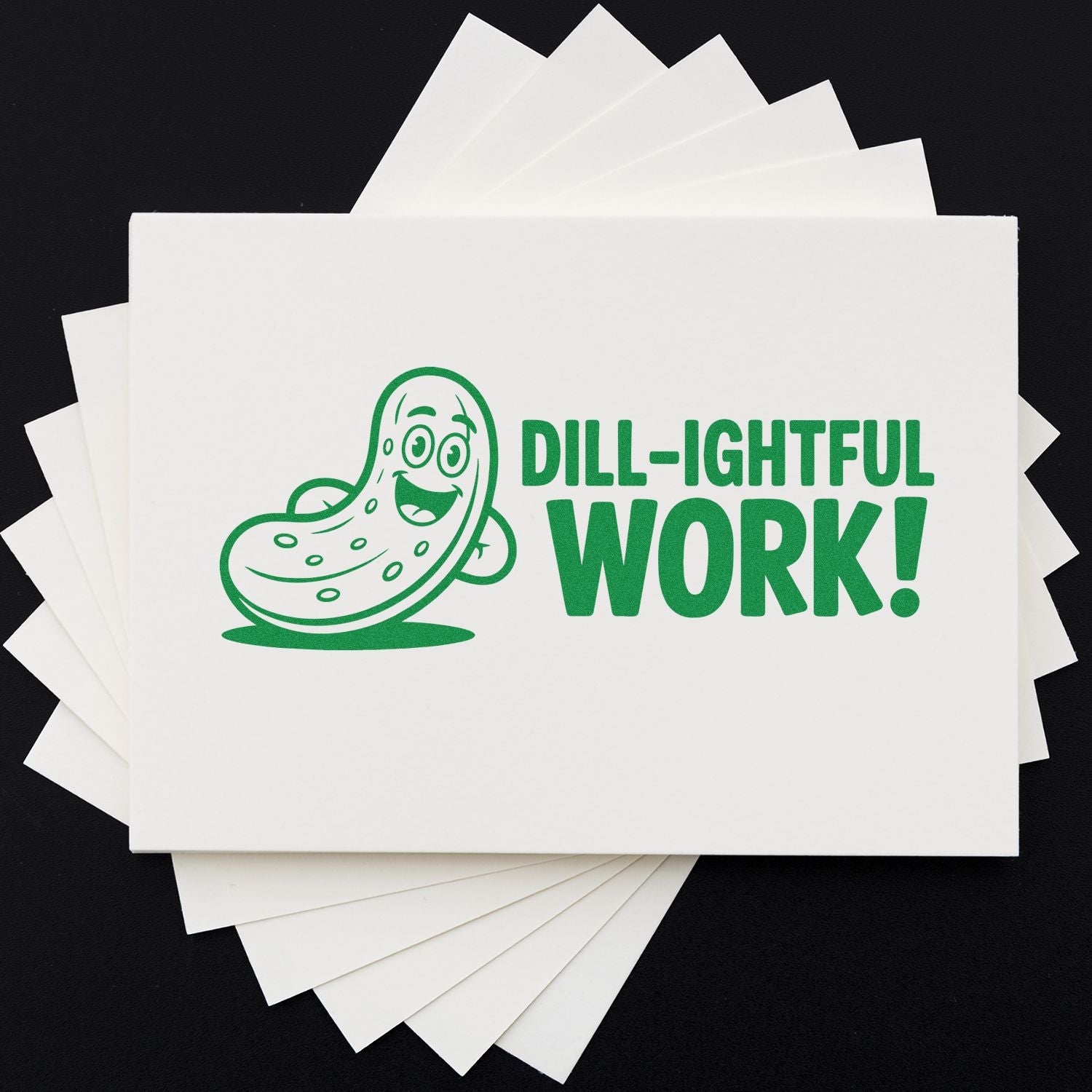 Green pickle stamp reading DILL-IGHTFUL WORK! on white cards, with stacked blank seal sheets on a black background.