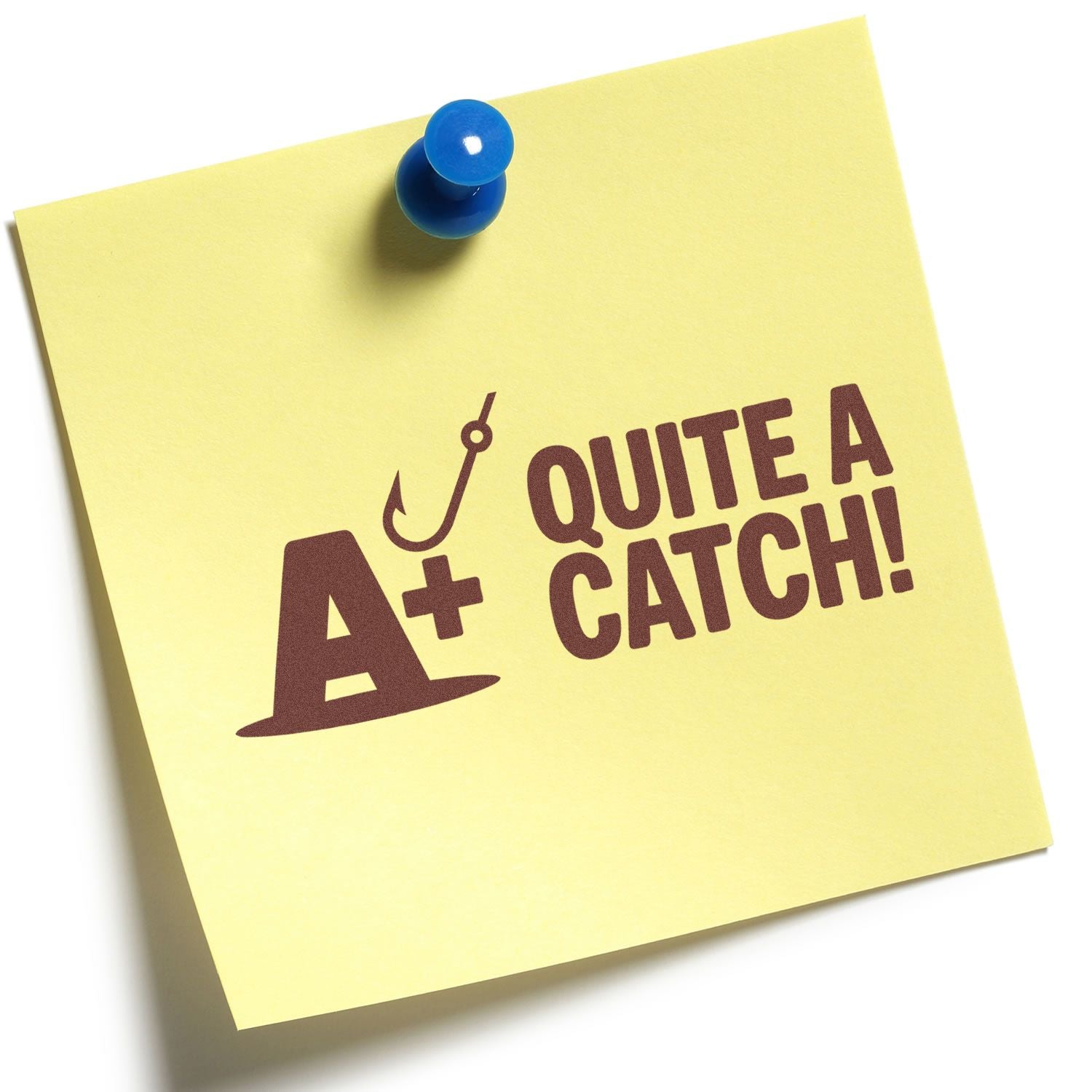 Yellow sticky note pinned with a blue pushpin, featuring maroon A+ Quite a Catch! hook stamp and seal design.
