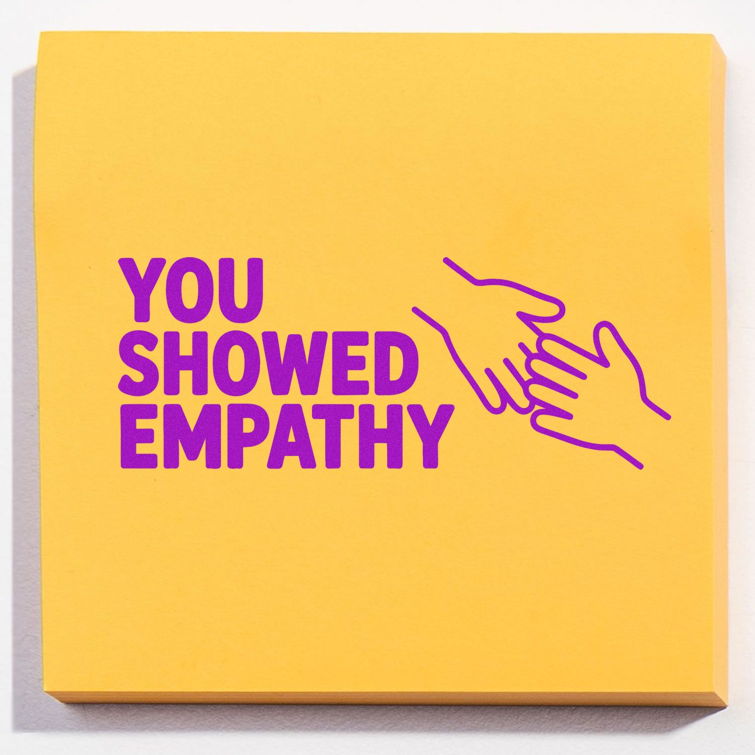 Yellow rubber stamp pad with purple You showed empathy text and handshake icon.