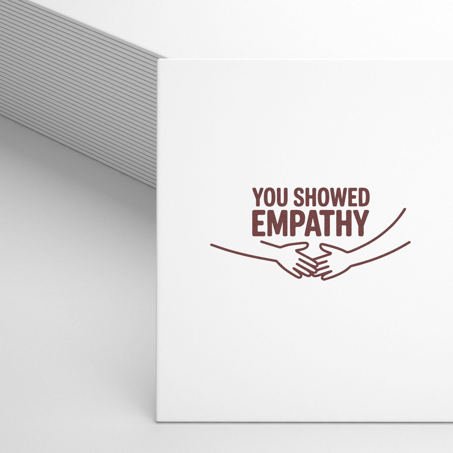 White stamp and seal product with brown YOU SHOWED EMPATHY text and handshake graphic on a clean white surface.